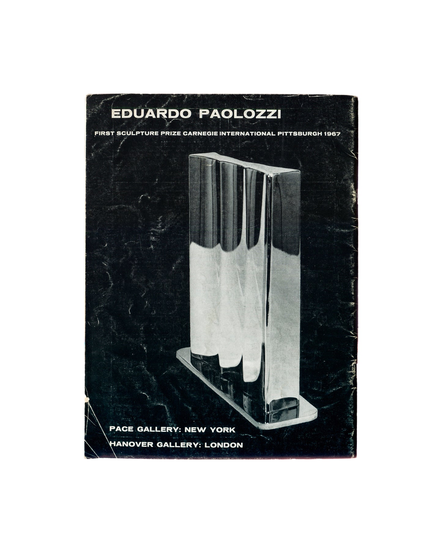 Back cover of Art and Artists, Vol. II, No. 8, November 1967. Full-page black-and-white exhibition advertisement for Eduardo Paolozzi, First Sculpture Prize Carnegie International Pittsburgh 1967. Black ground with bold white serif text: EDUARDO PAOLOZZI / FIRST SCULPTURE PRIZE CARNEGIE INTERNATIONAL PITTSBURGH 1967. Central photograph: chrome and aluminium sculpture — three tall cylindrical forms on a rectangular base, highly polished reflective surface. Lower text: PACE GALLERY: NEW YORK / HANOVER GALLERY