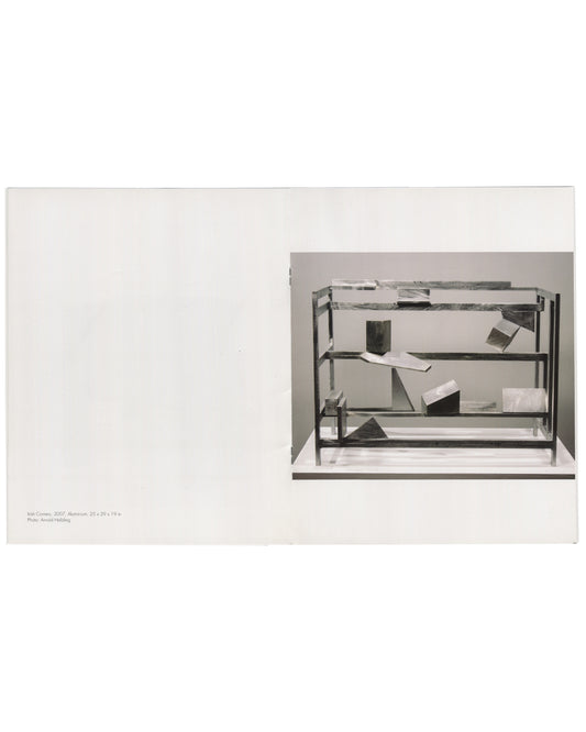 Willard Boepple, New Sculpture, Broadbent Gallery, London, 2008. Interior spread: left, white page blank; right, black-and-white photograph of Irish Corners (2007), aluminium, 25 × 29 × 19 in — open shelf framework with angled plates, irregular blocks and geometric forms suspended at varying heights. Caption lower left, photo credit Arnold Helbling.