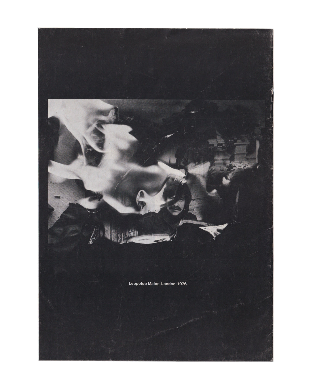 Back cover of Leopoldo Maler exhibition publication, London 1976. Black-and-white photograph of Maler lying amid flames and figures. Caption reads: Leopoldo Maler London 1976. Visible handling wear and edge scuffing consistent with vintage condition.