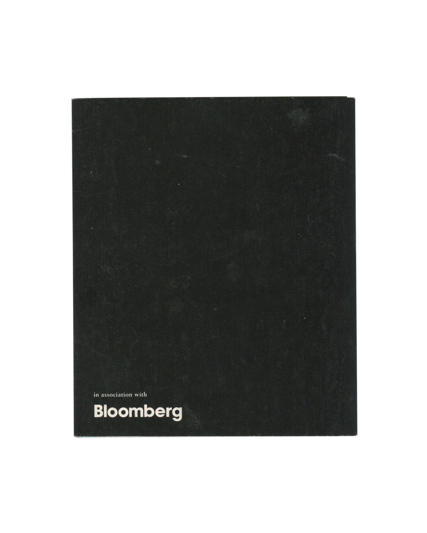 Reverse of 2000 fig-1 exhibition invitation for Patti Smith / Robert Mapplethorpe, Still / Moving, London, plain black card with in association with Bloomberg in small white sans-serif type at lower left.