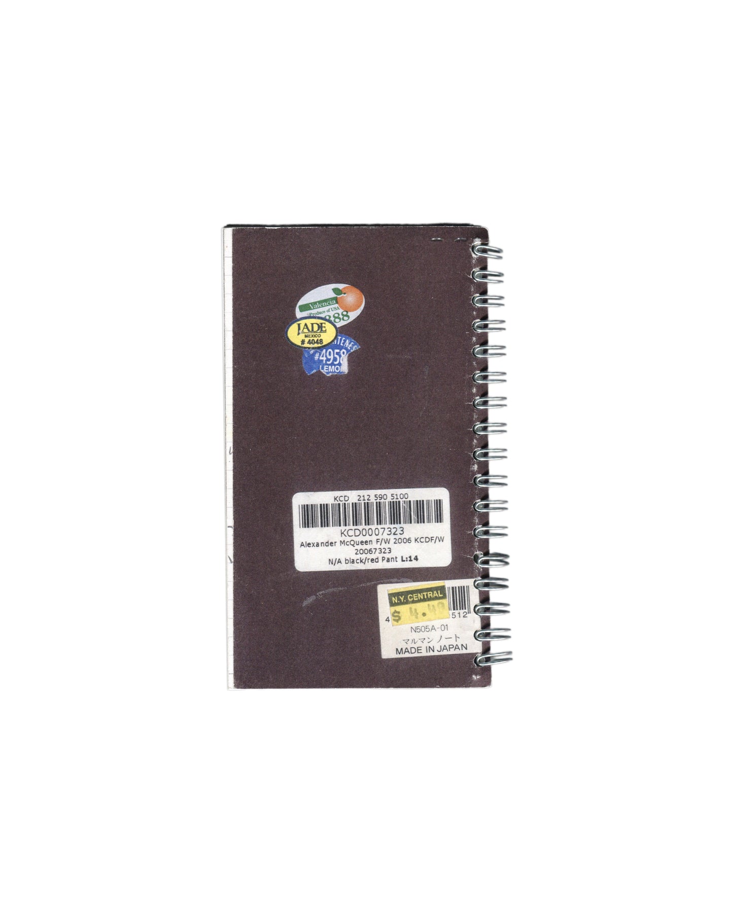 Back cover, Rafael Melendez, Keep Your Distance: A 2006 Facsimile Sketchbook, The Academy of Realness, 2021. Dark brown Crown Spiral notebook cover. Three labels: circular produce sticker upper left — Valencia #4388, Jade Mexico #4048, Lemon #4958, overlapping in blue, green, and yellow. Centre: printed barcode label — 'KCD 212 590 5100 / KCD0007323 / Alexander McQueen F/W 2006 KCDF/W 20067323 / N/A black/red Pant L:14'. Lower right: yellow N.Y. Central sticker — barcode, 'N505A-01 / マルマン ノート / MADE IN JAPA
