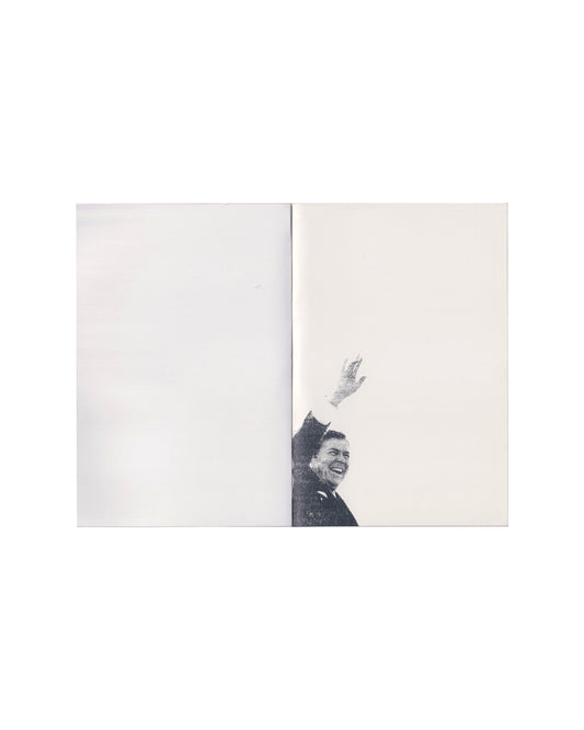 Peter Downsbrough, Take Note, Villa Arson, Nice, 1988. Interior spread: blank white pages with small black-and-white photograph of a man (Ronald Reagan) in a suit raising his hand, cropped at the gutter, lower left page blank