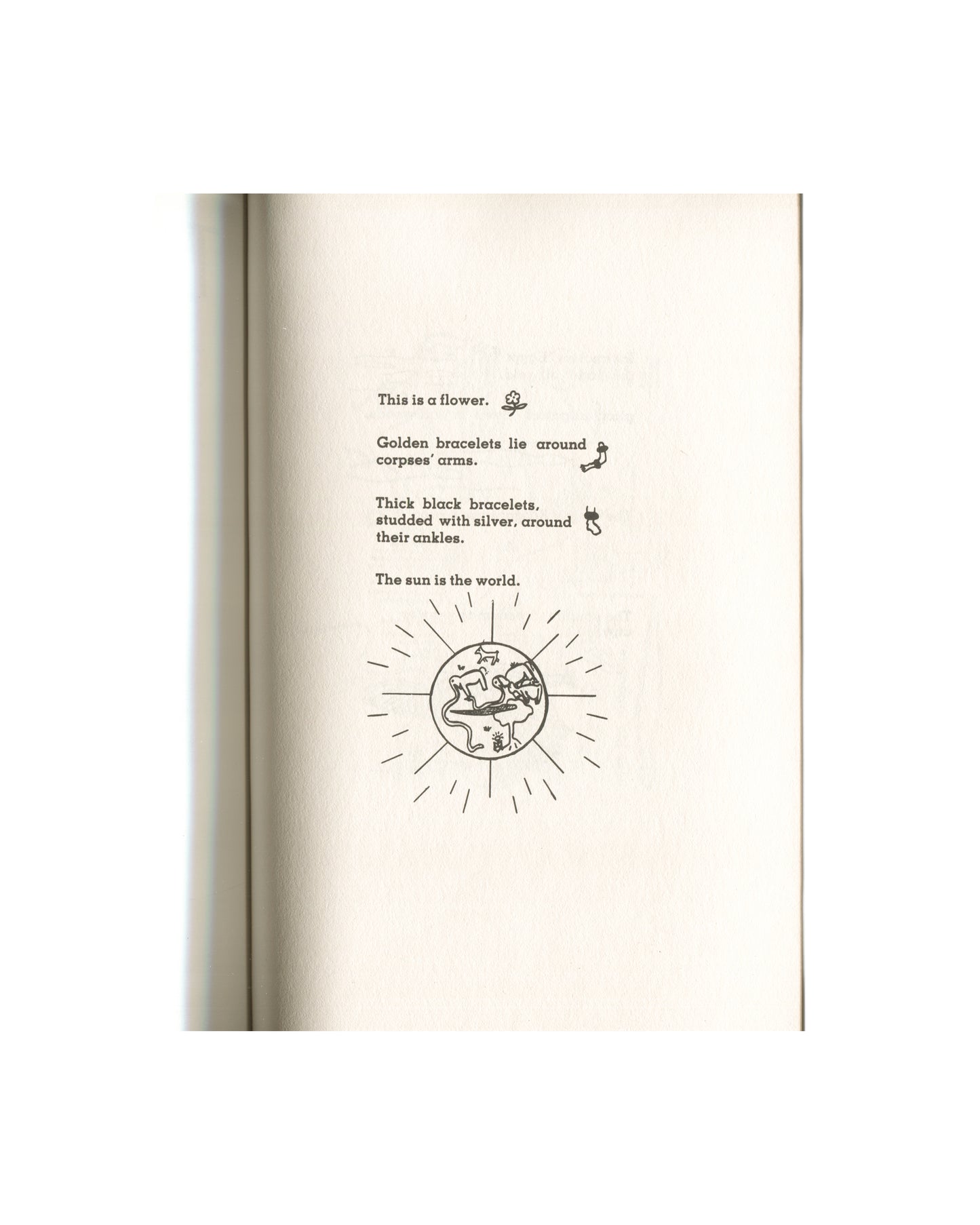 Kathy Acker — Blood and Guts in High School, Grove Press, 1984 — interior page. Continuation of "The World" section. Text: "This is a flower." with small floral symbol; "Golden bracelets lie around corpses' arms." with bracelet figure; "Thick black bracelets, studded with silver, around their ankles." with ankle figure; "The sun is the world." followed by a large circular sun diagram — a globe with radiating lines, figures and animals inside, rendered in Egyptian-style line drawing. Cream paper.