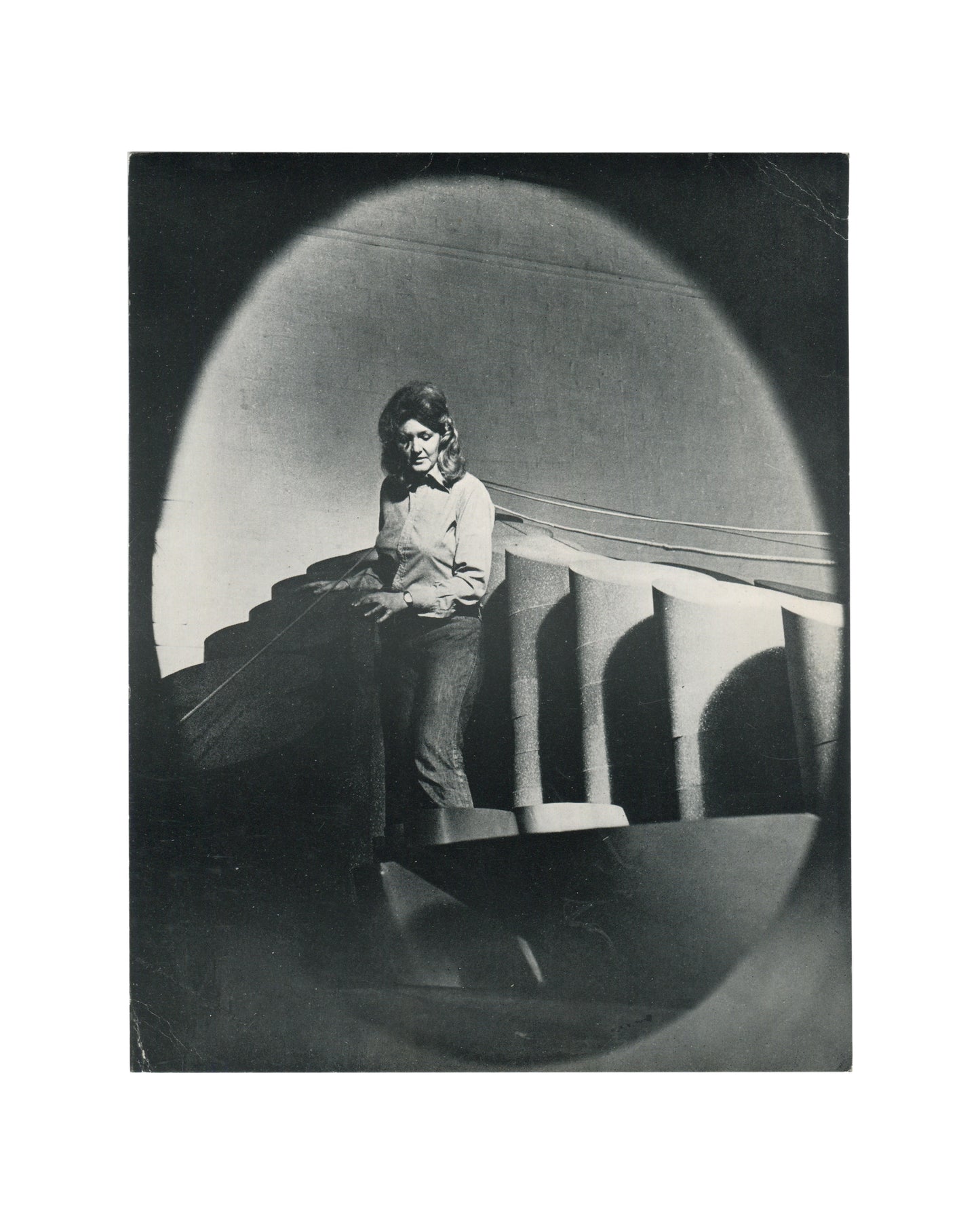 Original 1974 Anthea Alley exhibition card, Annely Juda Fine Art, London — recto showing black-and-white photographic portrait of the artist standing beside welded metal sculpture in a studio or exhibition space. Photograph by Jorge Lewinski.