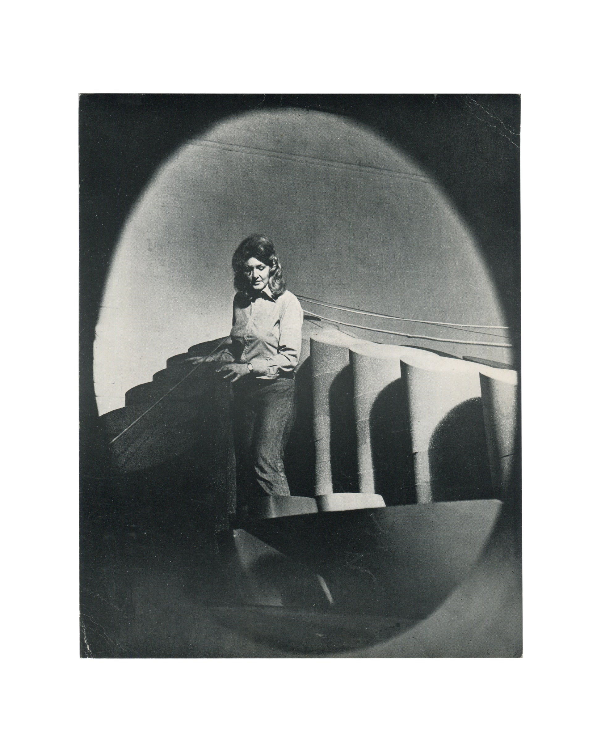 Original 1974 Anthea Alley exhibition card, Annely Juda Fine Art, London — recto showing black-and-white photographic portrait of the artist standing beside welded metal sculpture in a studio or exhibition space. Photograph by Jorge Lewinski.