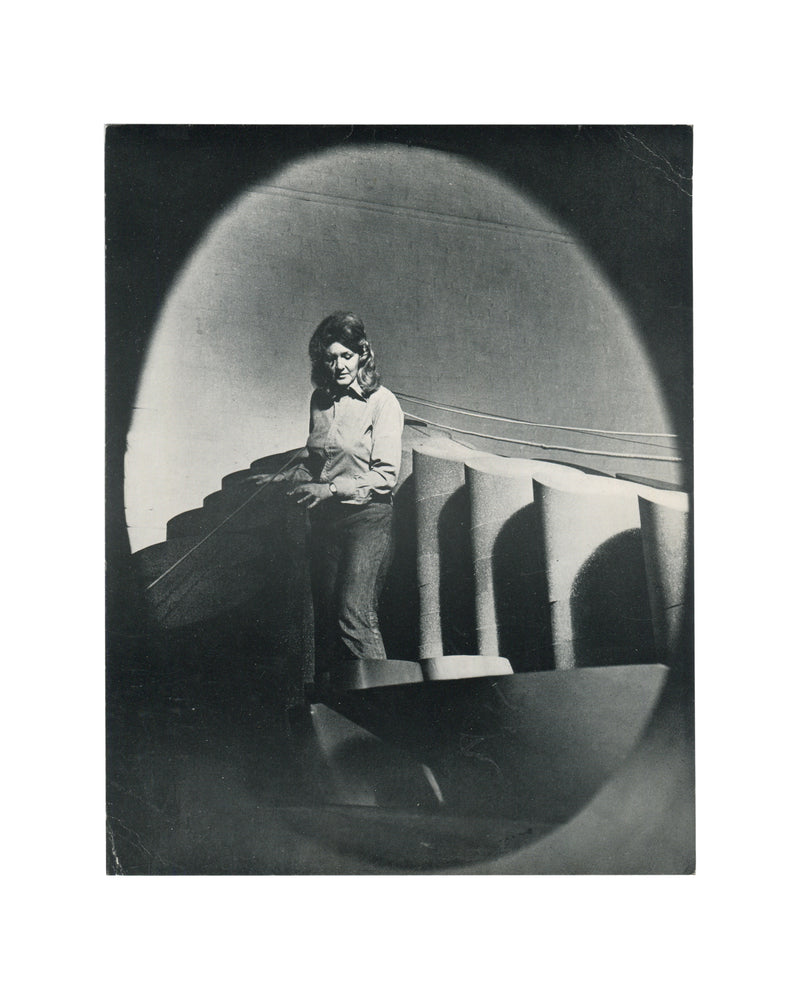 Original 1974 Anthea Alley exhibition card, Annely Juda Fine Art, London — recto showing black-and-white photographic portrait of the artist standing beside welded metal sculpture in a studio or exhibition space. Photograph by Jorge Lewinski.