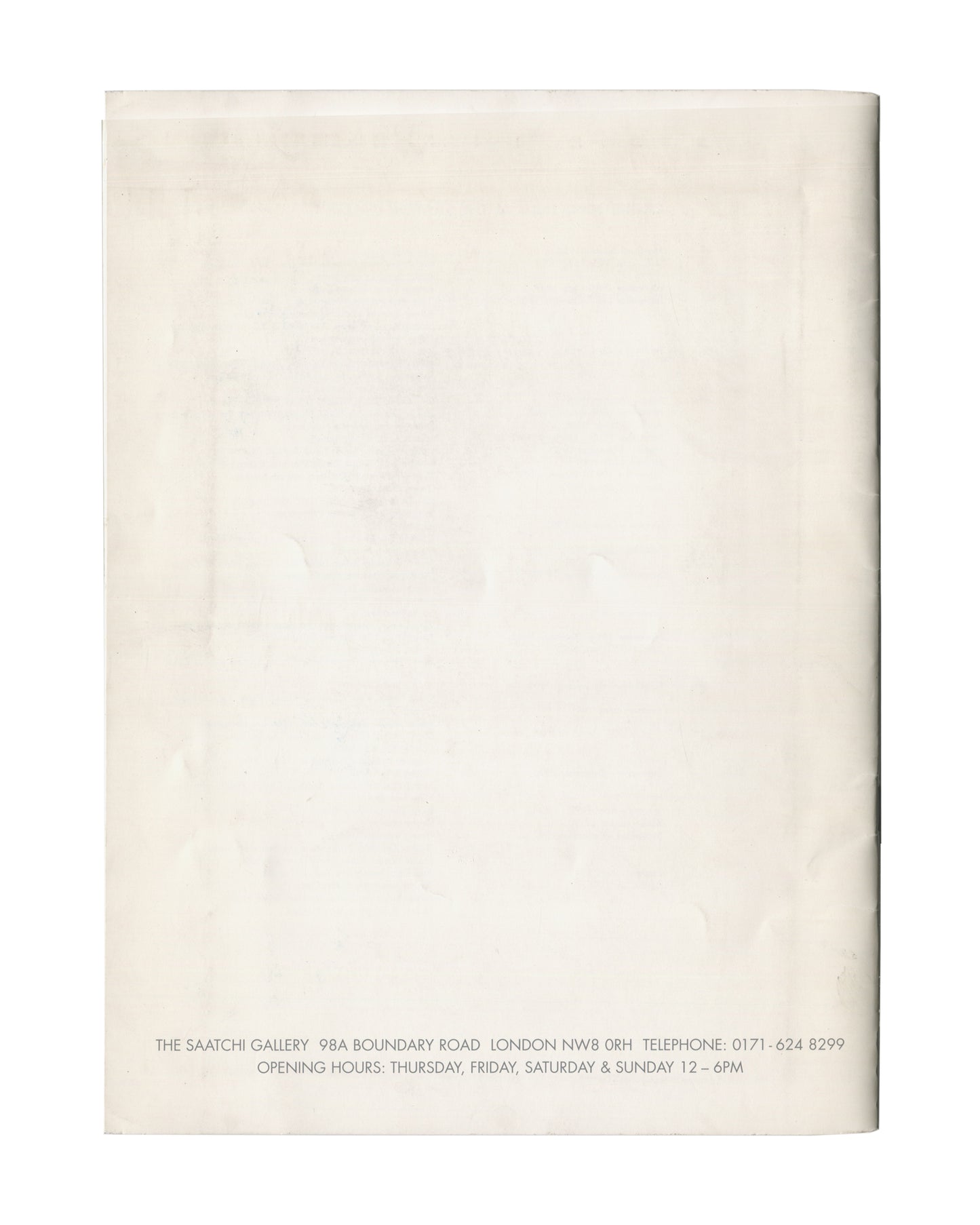 Reverse of 1998 Young Americans 2 Saatchi Gallery London exhibition catalogue showing plain cream-white stock with light age toning and surface marks, with small black sans-serif text at foot reading 'THE SAATCHI GALLERY 98A BOUNDARY ROAD LONDON NW8 0RH TELEPHONE: 0171-624 8299 / OPENING HOURS: THURSDAY, FRIDAY, SATURDAY & SUNDAY 12–6PM'.