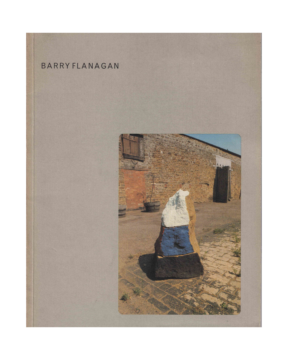 Barry Flanagan: Sculptures 1966–1976, exhibition catalogue cover — Van Abbemuseum, Arnolfini, Serpentine Gallery, 1977–1979 — grey card cover with colour photograph of outdoor stone and resin sculpture on cobbled courtyard