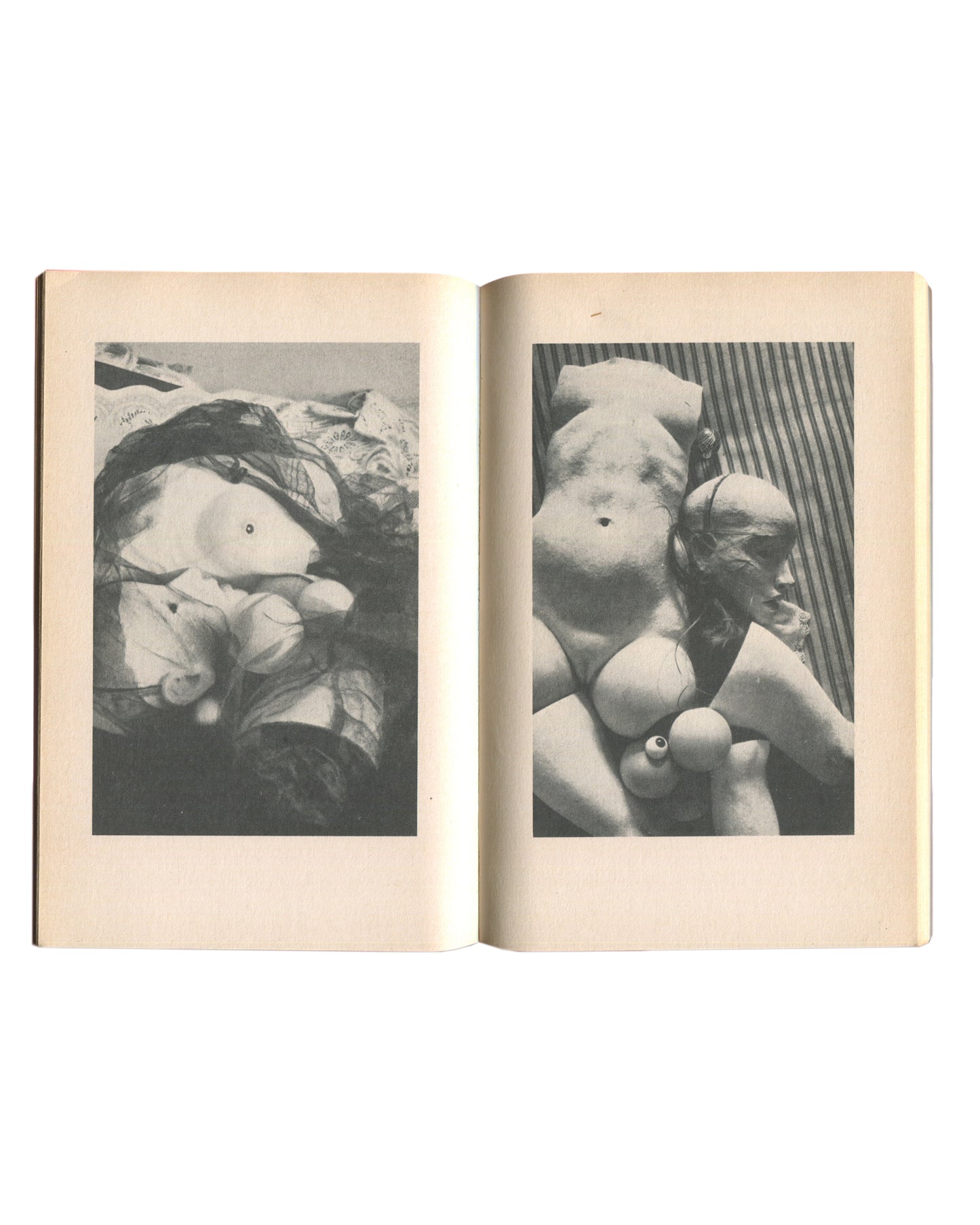 Interior spread of 1976 Hans Bellmer Die Puppe — two black-and-white photographs of disassembled doll parts: left image showing a torso fragment amid fabric; right image showing a headless torso with a detached glass eye in the foreground against a striped background
