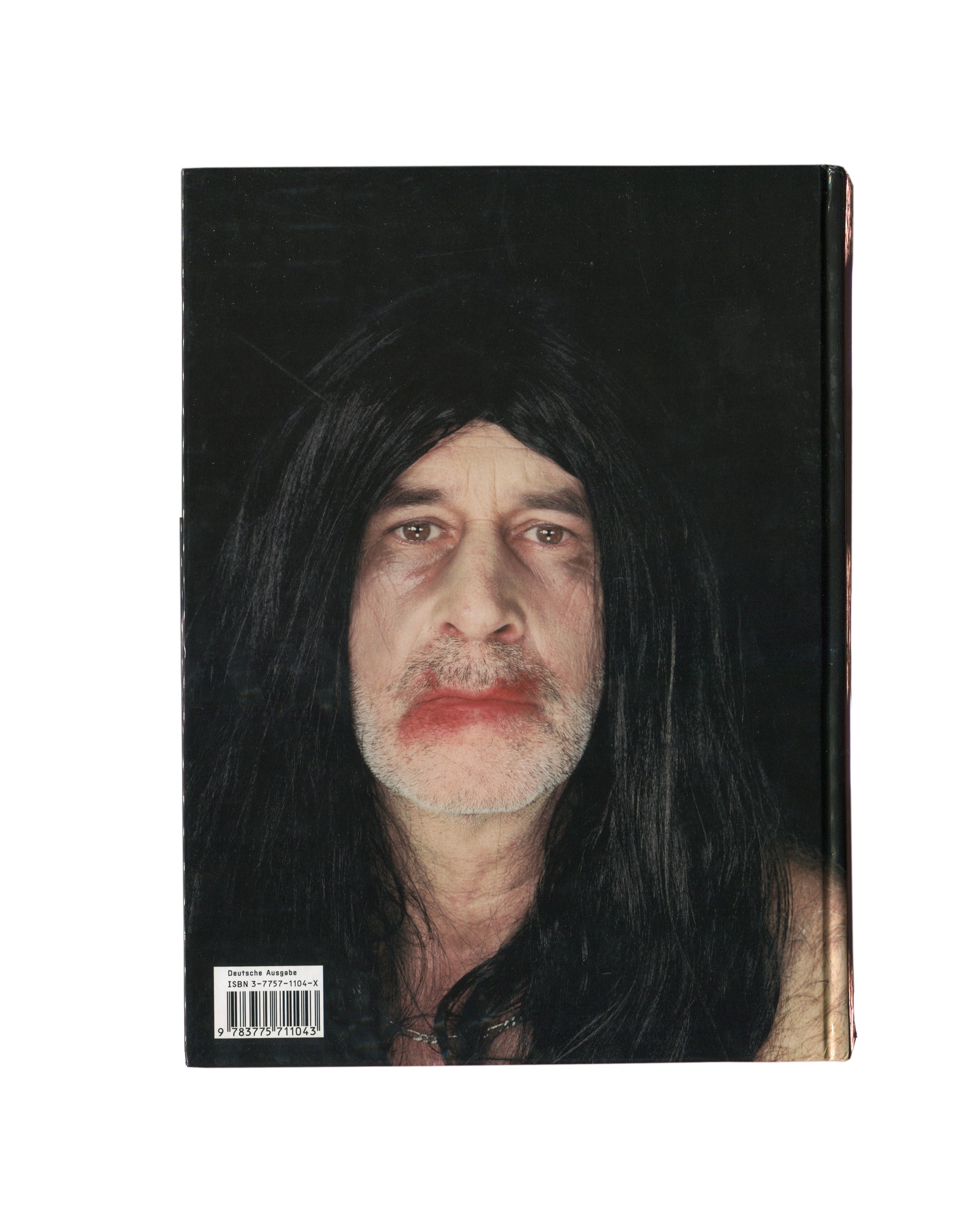 Reverse of 2001 Olaf Breuning Ugly, Hatje Cantz — hardcover back showing full-bleed colour photograph of a shirtless young man in aviator sunglasses and black wig covered in temporary tattoos including a large tiger on the abdomen, holding a Gatorade bottle, standing outdoors against a rocky background in red Champion shorts
