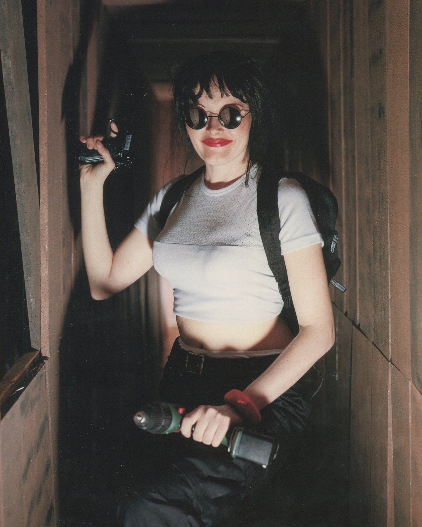 Interior spread of 2001 Olaf Breuning Ugly — full-page colour photograph of a shirtless man in black wig and aviator sunglasses covered in temporary tattoos including a large tiger, skulls, roses, kanji characters, and tribal designs, holding a supplement jar, red shorts, rocky outdoor setting
