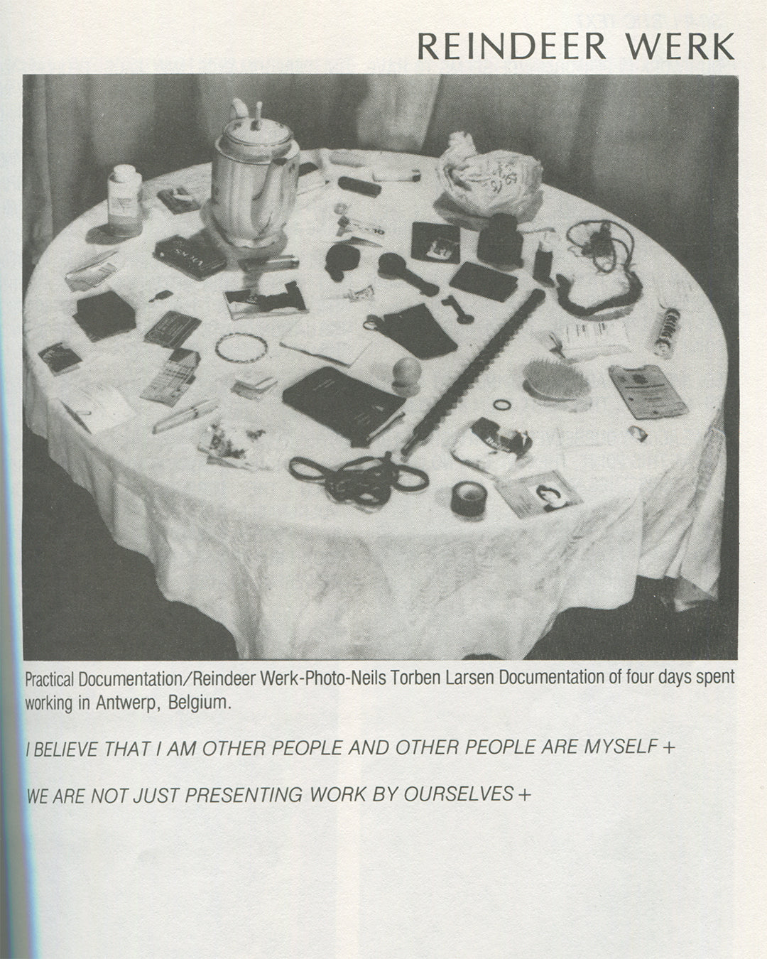 Interior page from 1979 Performance by Artists, Art Metropole. Reindeer Werk section showing a black-and-white photograph of a round table covered with personal objects, tools, and documents, captioned as practical documentation from four days in Antwerp, Belgium, photo by Neils Torben Larsen.