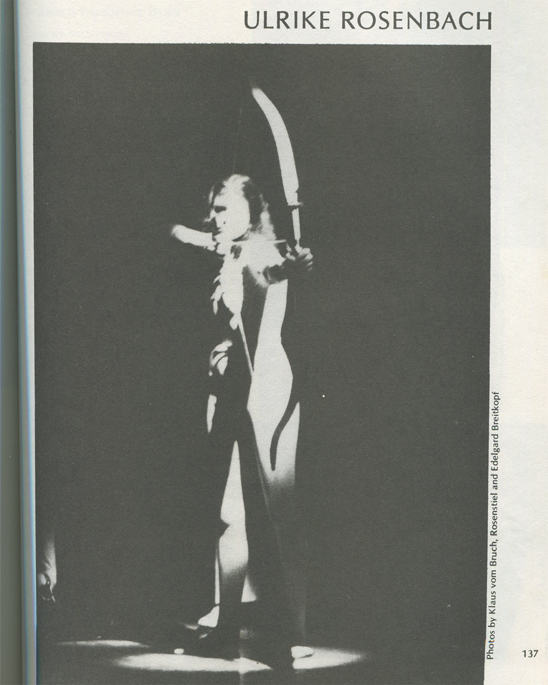 Interior page from 1979 Performance by Artists, Art Metropole, page 137. Black-and-white photograph of Ulrike Rosenbach in performance, figure in dramatic spotlight holding a large curved blade above her head, photos credited to Klaus vom Bruch, Rosenstiel and Edelgard Breitkopf.