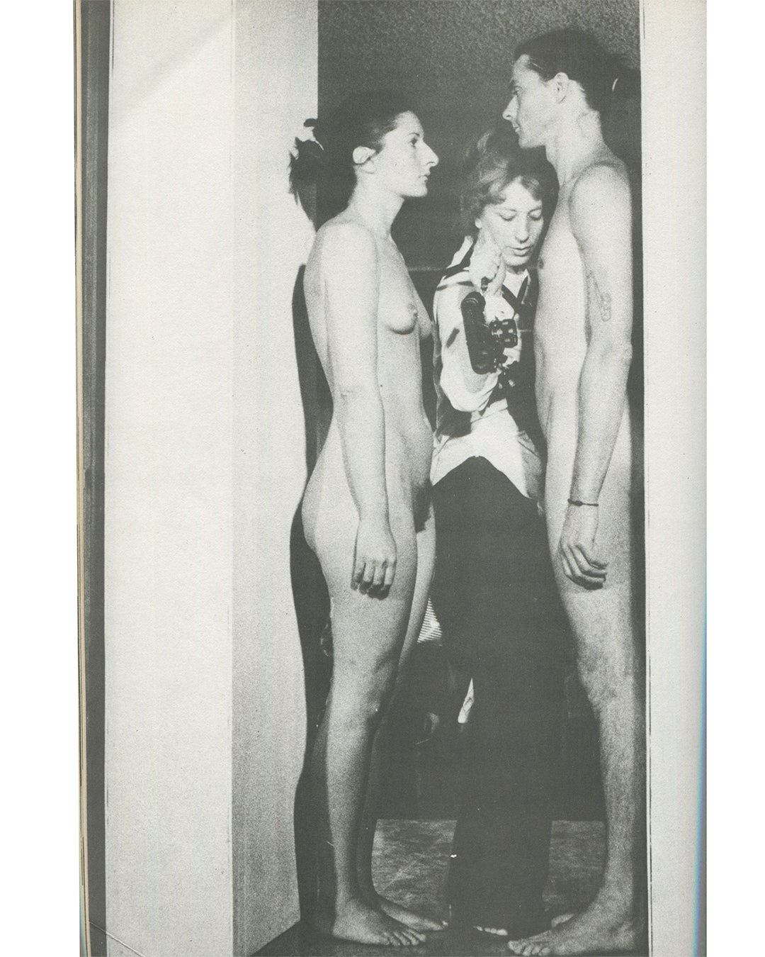 Interior page from 1979 Performance by Artists, Art Metropole. Black-and-white photograph of Ulay and Marina Abramovic in a durational performance, two nude figures facing each other with a clothed photographer between them in a narrow doorway.