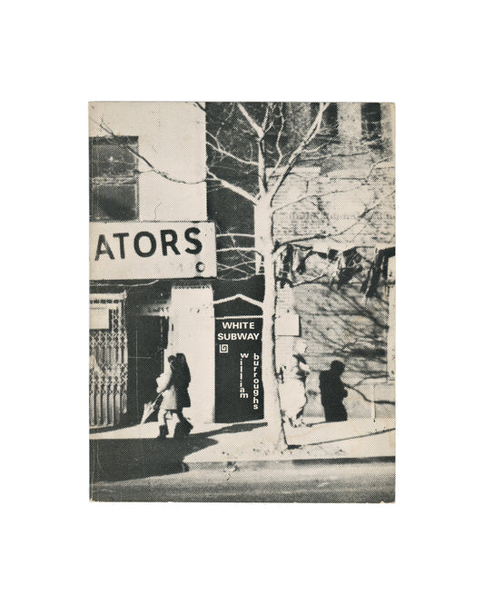 Original 1973 William S. Burroughs White Subway, Aloes Books, London, first edition. Photo-illustrated softcover showing a collaged black-and-white street photograph: a building facade with a partially visible sign reading 'ATORS' at upper left, a bare winter tree at centre, and a figure walking on the pavement below, with 'WHITE SUBWAY' and 'william burroughs' in white type overlaid on the image.