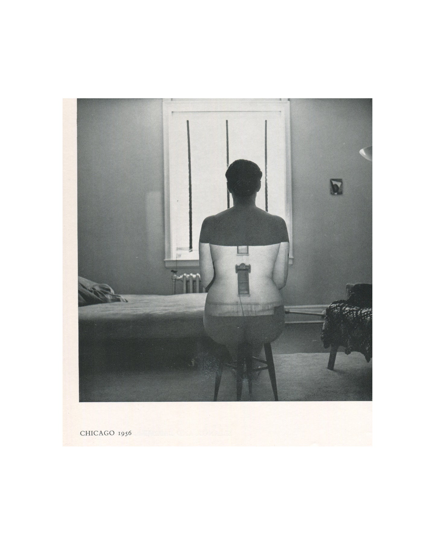 Interior page from 1967 Harry Callahan, Museum of Modern Art. Caption reads 'CHICAGO 1956'. Black-and-white photograph of a nude female figure seen from behind, seated on a stool before a window with venetian blinds casting vertical light, a bed and lamp visible in the domestic interior around her.