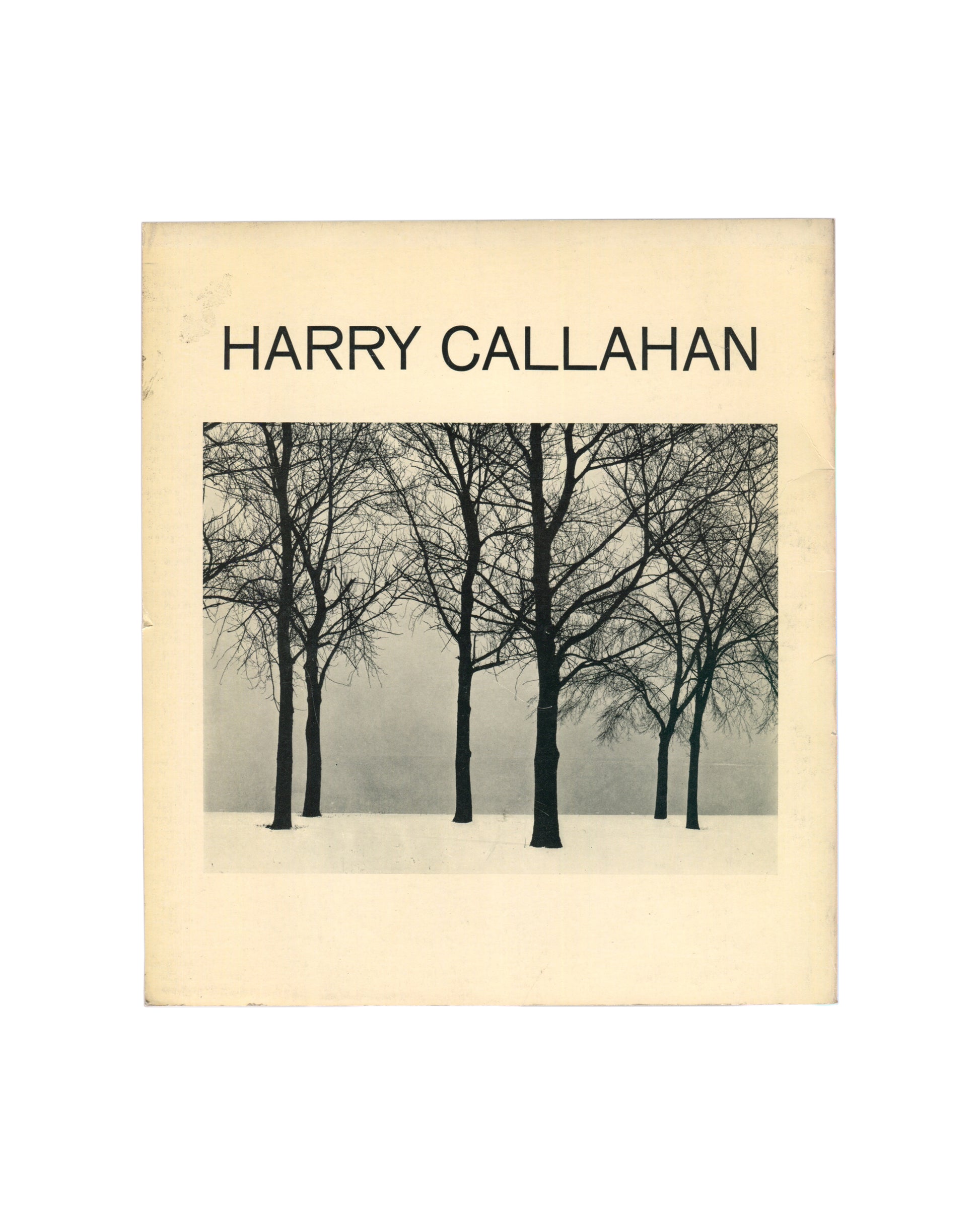 Original 1967 Harry Callahan exhibition catalogue, Museum of Modern Art, New York. Cream softcover with 'HARRY CALLAHAN' in large sans-serif type above a black-and-white photograph of six bare winter trees standing in snow against a pale grey sky, their dark trunks and branching silhouettes filling the frame.