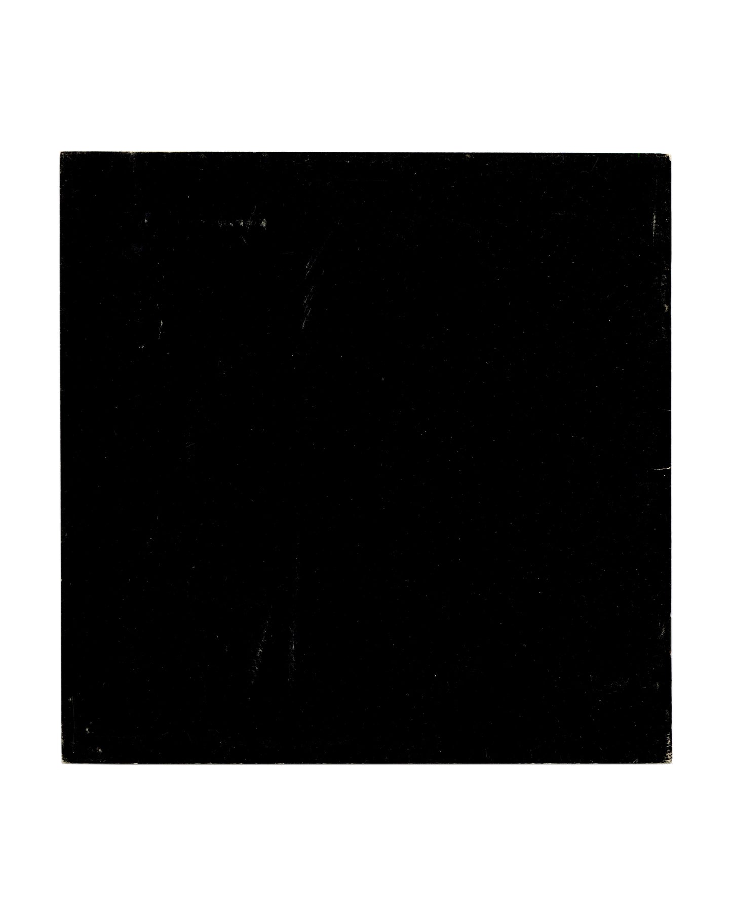  Back cover showing solid black ground with pronounced rubbing, scratching and edge wear consistent with vintage handling and circulation.