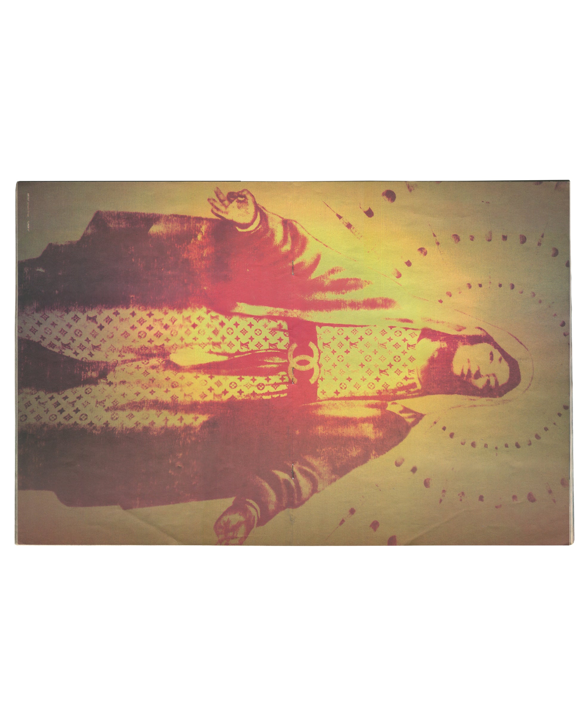 nterior page from 2012 Lovecat Issue 3. Full-page image by Mr. Brainwash showing a Virgin Mary figure rendered in warm golden-yellow tones, robed in Louis Vuitton monogram fabric with a Chanel logo at centre, surrounded by a halo of dots and radiating light, two flanking figures partially visible.
