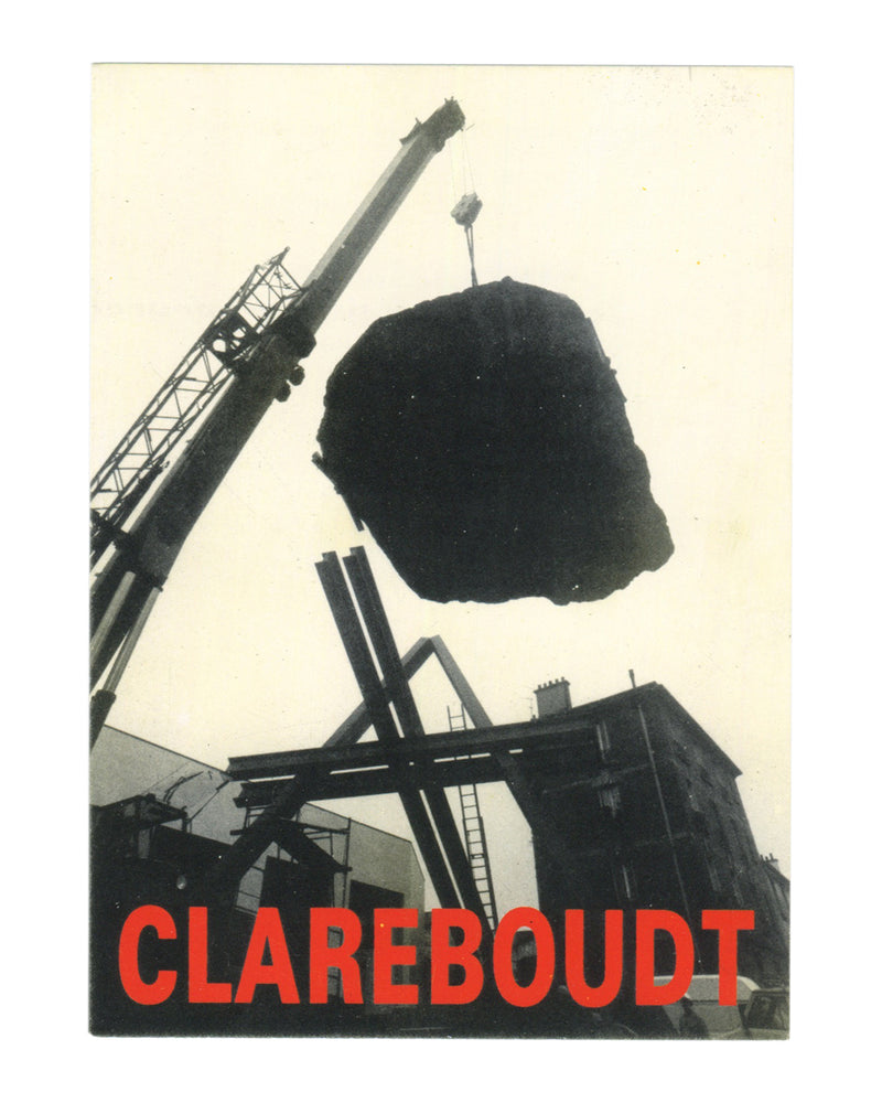 Jean Clareboudt, Oblique Haute, exhibition invitation recto. CREDAC Centre d'Art Contemporain, Galerie Fernand Léger, Ivry-sur-Seine, 1990. Black-and-white photograph: a large irregular dark mass — a boulder or raw stone — suspended from a crane arm against a pale overcast sky. The crane extends diagonally from the upper left; industrial steel structures, scaffolding, and a brick building are visible below and behind. Low-angle shot emphasising the weight and scale of the suspended object. 'CLAREBOUDT' in l