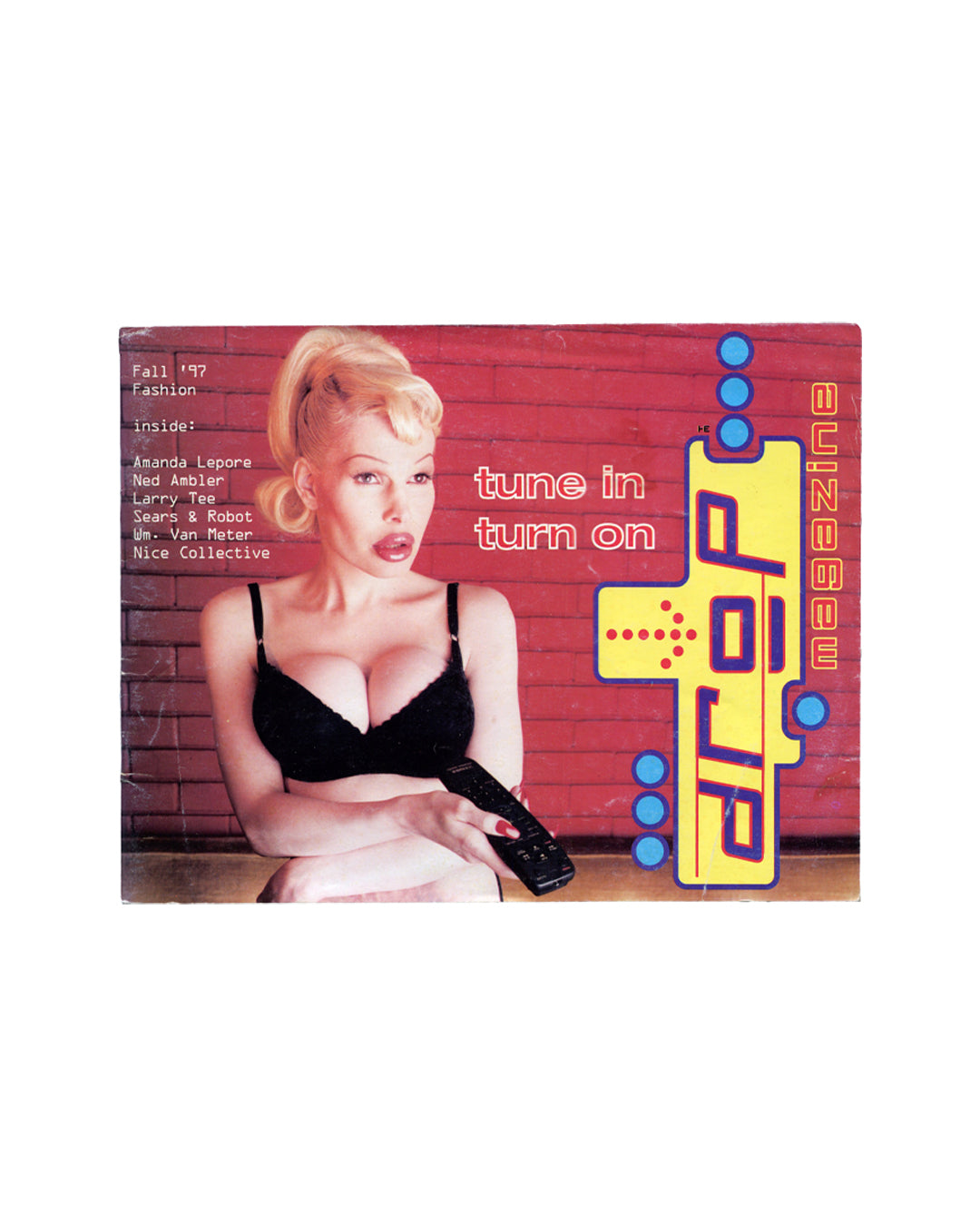 Cover of Drop Magazine, Fall/Winter 1997, New York, showing Amanda Lepore in a black bra holding a mobile phone against a red brick wall, with the text "tune in turn on" and a contents list including Amanda Lepore, Ned Ambler, Larry Tee, Sears and Robot, Wm. Van Meter, Nice Collective, and the Drop Magazine logo in yellow and blue at right.