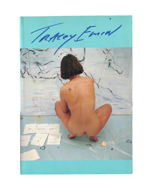 Tracey Emin — I Need Art Like I Need God, Jay Jopling/London, 1998. Front cover. Turquoise ground, handwritten blue signature 'Tracey Emin' upper left. Centre: photograph of the artist nude from behind, crouching on a studio floor, facing a large gestural canvas. Published for her 1997 exhibition at South London Gallery.