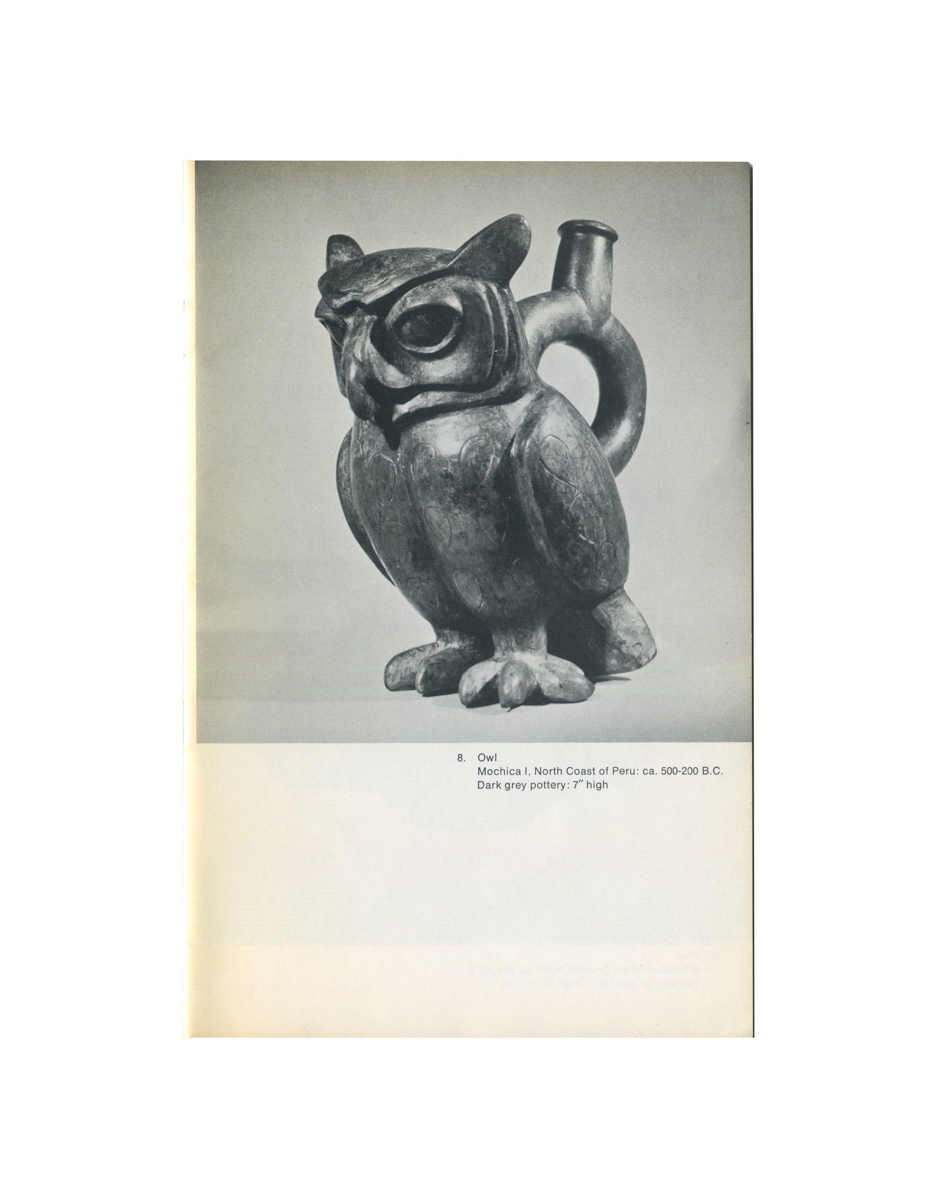 `Animals in Pre-Columbian Art — André Emmerich Gallery — interior plate. Cat. no. 8, Owl, Mochica I, North Coast of Peru, ca. 500–200 B.C. Dark grey pottery stirrup-spout vessel modelled as a seated owl: large circular eyes, flat beak, incised feather detail on wings and body, taloned feet, handle and spout rising from the back. 7" high.`