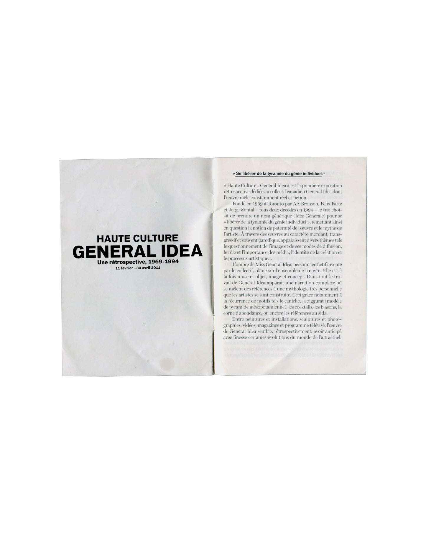 Interior spread General Idea, Haute Culture: Une rétrospective, 1969–1994, Musée d'Art moderne de la Ville de Paris, 2011. Booklet interior spread: left page, exhibition title in large bold black serif — 'HAUTE CULTURE / GENERAL IDEA / Une rétrospective, 1969–1994 / 11 février – 30 avril 2011' on white ground; right page, pull quote in italic — '«Se libérer de la tyrannie du génie individuel»' followed by two columns of dense French critical text in small serif type. Light handling marks.