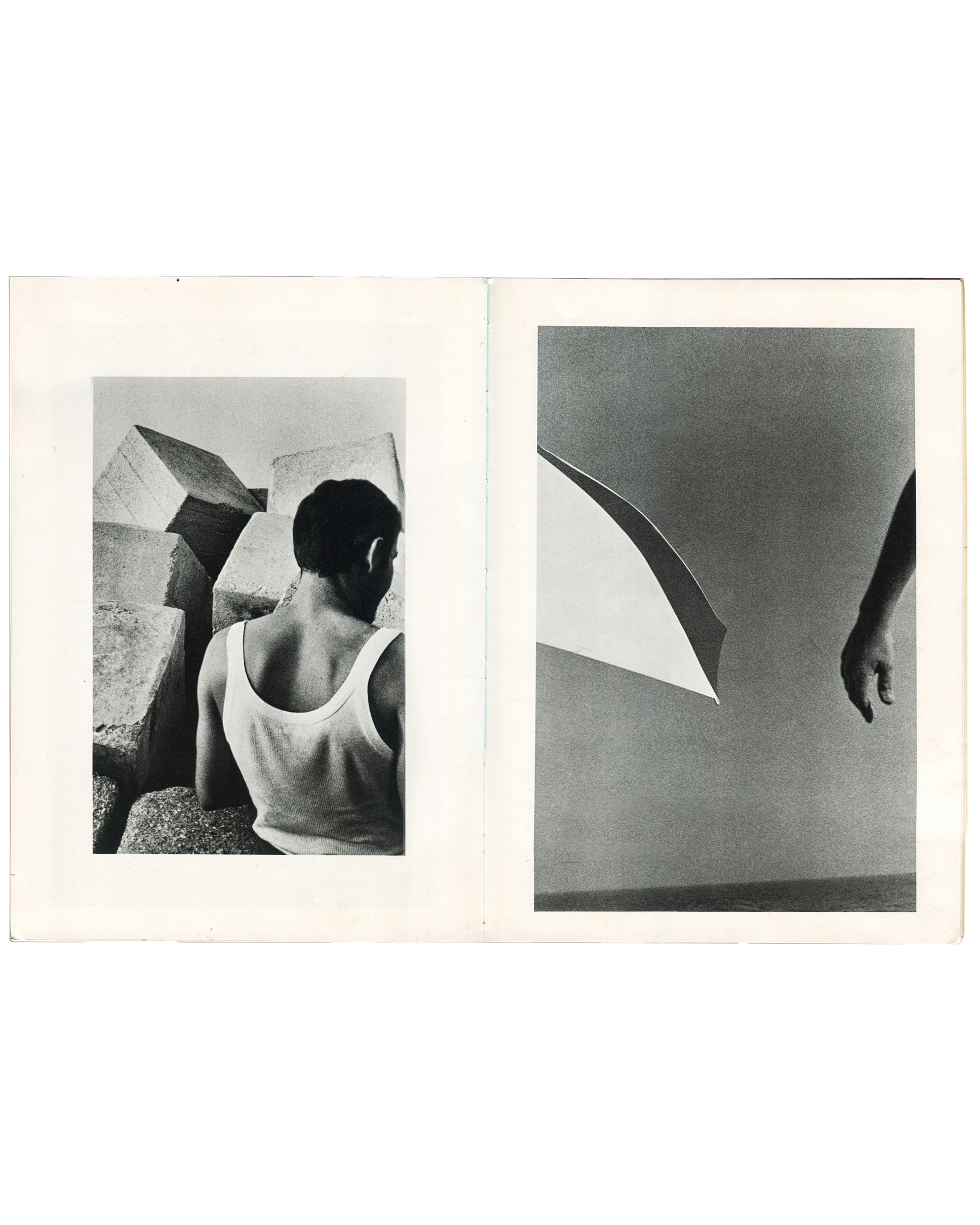  Interior spread of Ralph Gibson, Deja-Vu, Lustrum Press, 1973, left page showing a figure in a white vest seen from behind amid large stone blocks, right page showing a curved architectural form and a hanging hand against a pale sky.