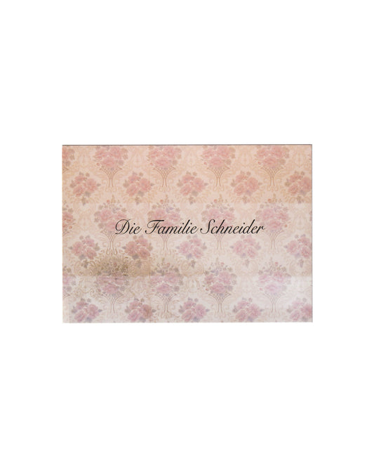 Recto (front):

Gregor Schneider, Die Familie Schneider, Konrad Fischer Galerie, Berlin, 2014. Recto: printed card with repeating soft pink floral wallpaper motif on cream ground; title Die Familie Schneider set in dark script at centre.