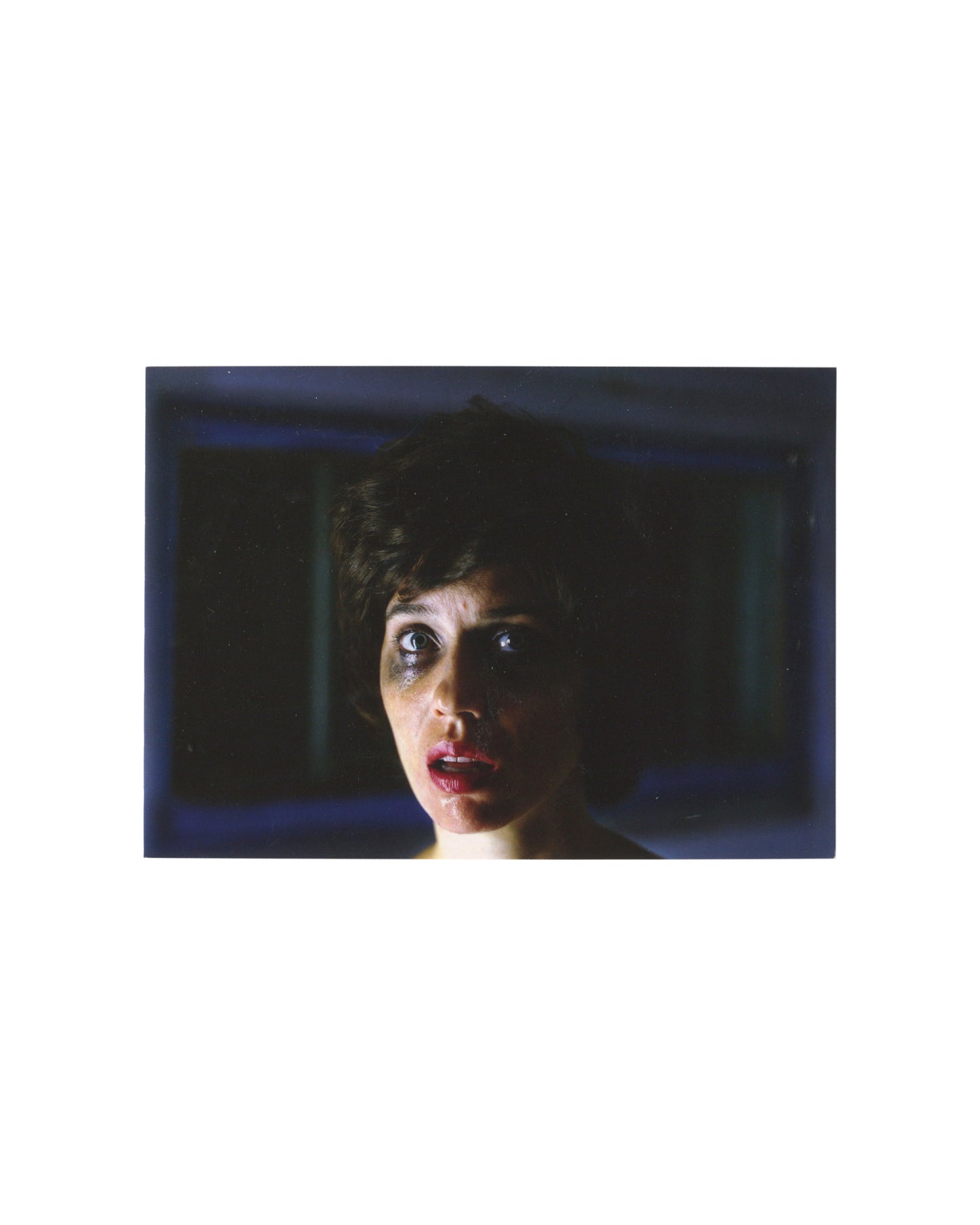 Aneta Grzeszykowska, Untitled Film Stills #30, 2006, c-print, Raster Gallery Warsaw. Close-up of young woman with short dark hair, wide eyes, smudged mascara, open mouth, lit against dark blue interior; restaged after Cindy Sherman.