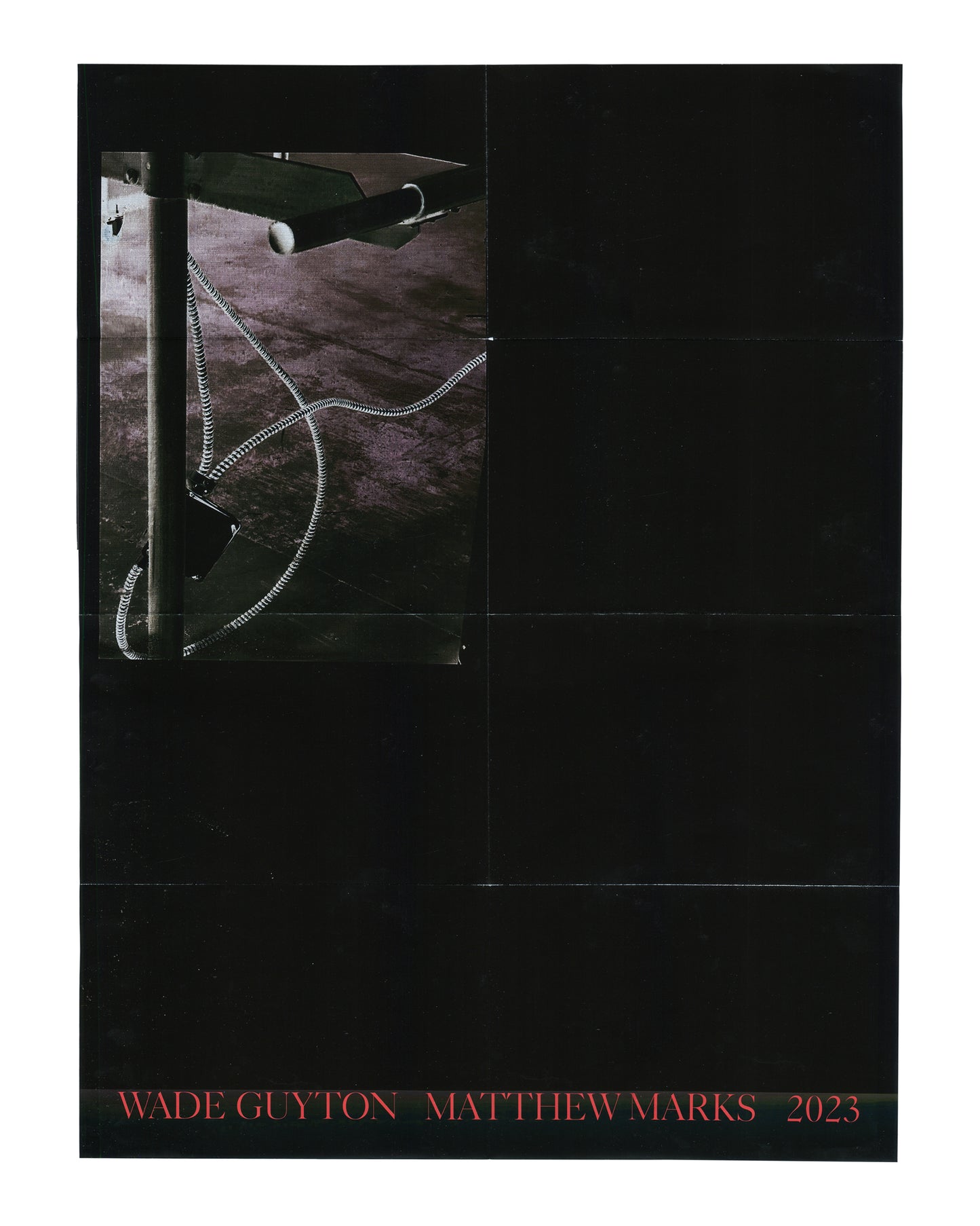 Original exhibition poster, Wade Guyton, Matthew Marks Gallery, New York, September 14 – October 28, 2023. Offset lithograph, 46 × 61 cm. Folded as issued. Black ground. Upper left: large colour photograph inset — close-up of a metal studio rack or table leg with a coiled black-and-white striped cable or hose looping across a dark floor surface. Remainder of poster: solid black. Lower margin: red serif text 'WADE GUYTON  MATTHEW MARKS  2023'. Horizontal fold lines visible across full poster surface; light h