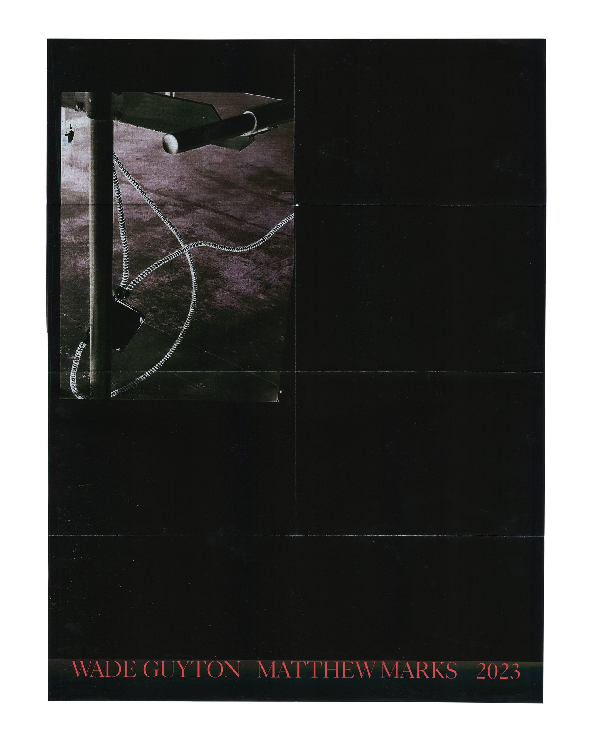 Original exhibition poster, Wade Guyton, Matthew Marks Gallery, New York, September 14 – October 28, 2023. Offset lithograph, 46 × 61 cm. Folded as issued. Black ground. Upper left: large colour photograph inset — close-up of a metal studio rack or table leg with a coiled black-and-white striped cable or hose looping across a dark floor surface. Remainder of poster: solid black. Lower margin: red serif text 'WADE GUYTON  MATTHEW MARKS  2023'. Horizontal fold lines visible across full poster surface; light h