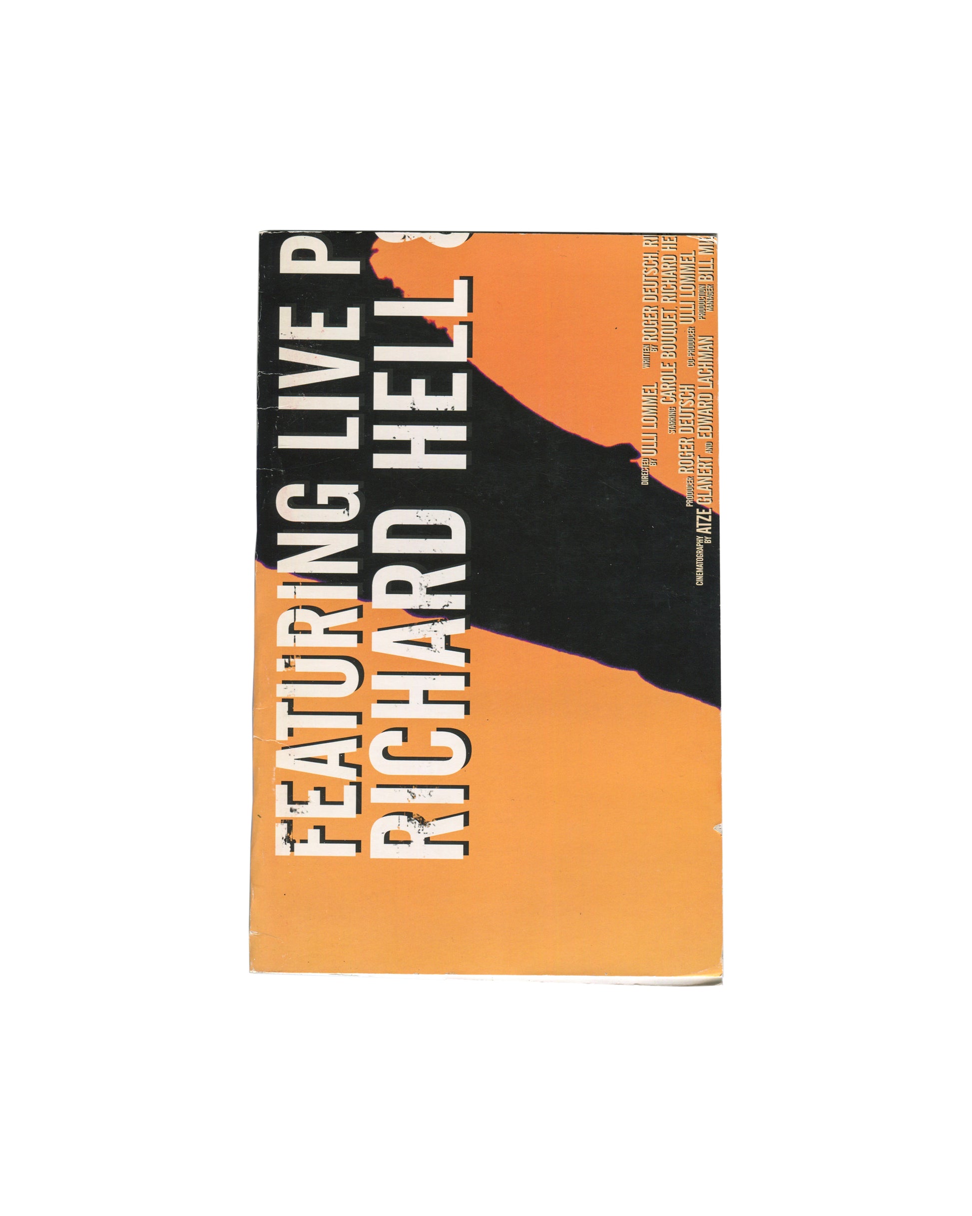 Front cover Artist book, Richard Hell / Josh Smith, Disgusting, 38th Street Publishers, New York, 2010. Front cover: heavy card cut from a promotional poster for the DVD reissue of Blank Generation (dir. Ulli Lommel, 1980). Orange ground with large bold black and white type reading: FEATURING LIVE P[ERFORMANCE] / RICHARD HELL[S]. Right edge carries vertical film credits in small type: directed by Ulli Lommel; starring Carole Bouquet, Richard He[ll]; produced by Roger Deutsch, Olli Lommel; cinematography by 