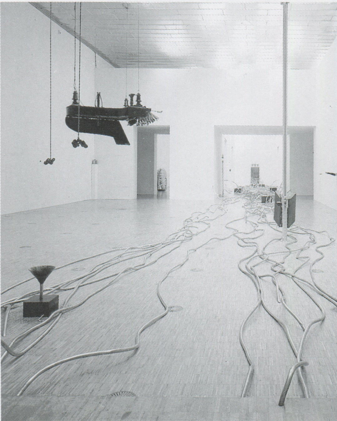 Rebecca Horn, Concert for Anarchy 1990, installation view: upside-down grand piano suspended from ceiling, silver tubes coiled across gallery floor