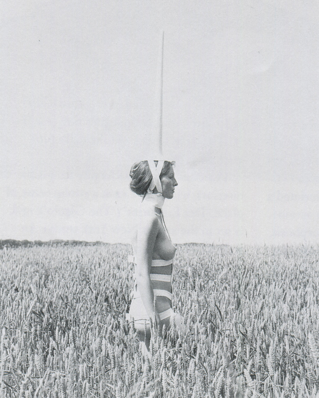 Rebecca Horn, Unicorn 1970–72, interior spread: performer wearing vertical white tube body extension, standing on metal base, Tate 1994
