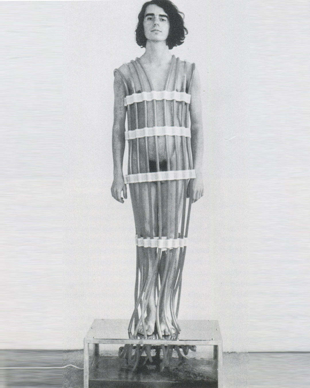 Rebecca Horn, Körper-Fächer 1972, performance still: performer standing on metal base wearing vertical tube body extension encasing full torso and legs