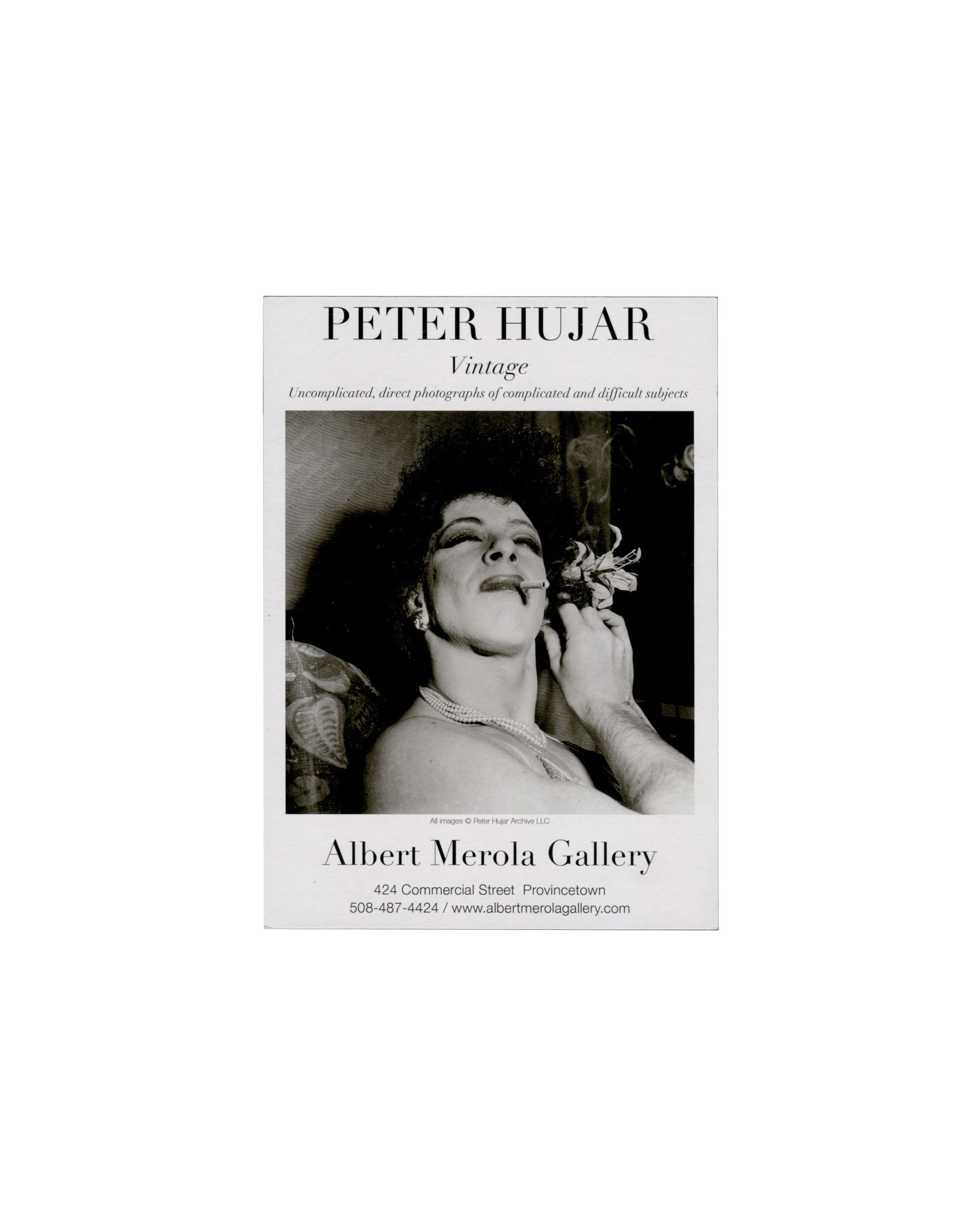 Recto — portrait with bouffant wig Peter Hujar, Vintage, Albert Merola Gallery, Provincetown, 2022. Announcement recto: monochrome photograph of a figure with an elaborate pale bouffant wig, head tilted downward, eyes cast down, bare shoulders; dramatic high-contrast lighting against dark ground; 'PETER HUJAR' in large serif caps above image; 'Albert Merola Gallery / July 1–27, 2022' in serif below; copyright credit 'All images © Peter Hujar Archive LLC' in small type within image.