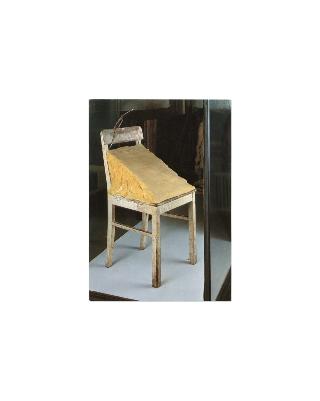 Postcard, Joseph Beuys, Der Fett-Stuhl / Chaise de graisse / The Grease-Chair, Hessisches Landesmuseum Darmstadt. Vontobel Kunstkartendruck, Feldmeilen/Zürich, 1982. Offset colour reproduction — white-painted wooden chair with large wedge of yellow fat on seat; twig tied to chair back; grey gallery floor, glass vitrine wall behind. Good vintage condition, light age toning.