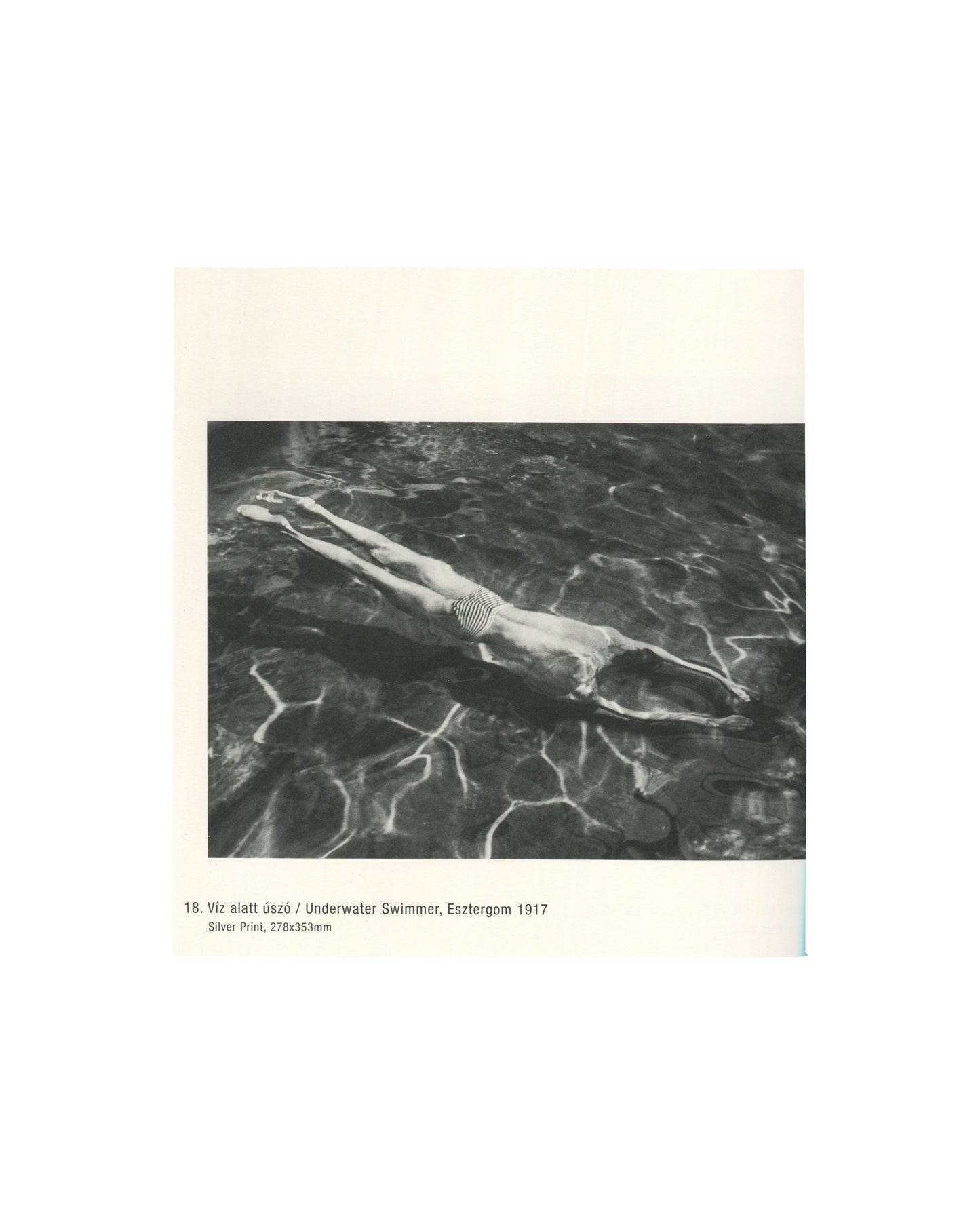 Black-and-white photograph of a swimmer floating underwater in Esztergom, Hungary, 1917. Light reflections ripple across the water's surface.