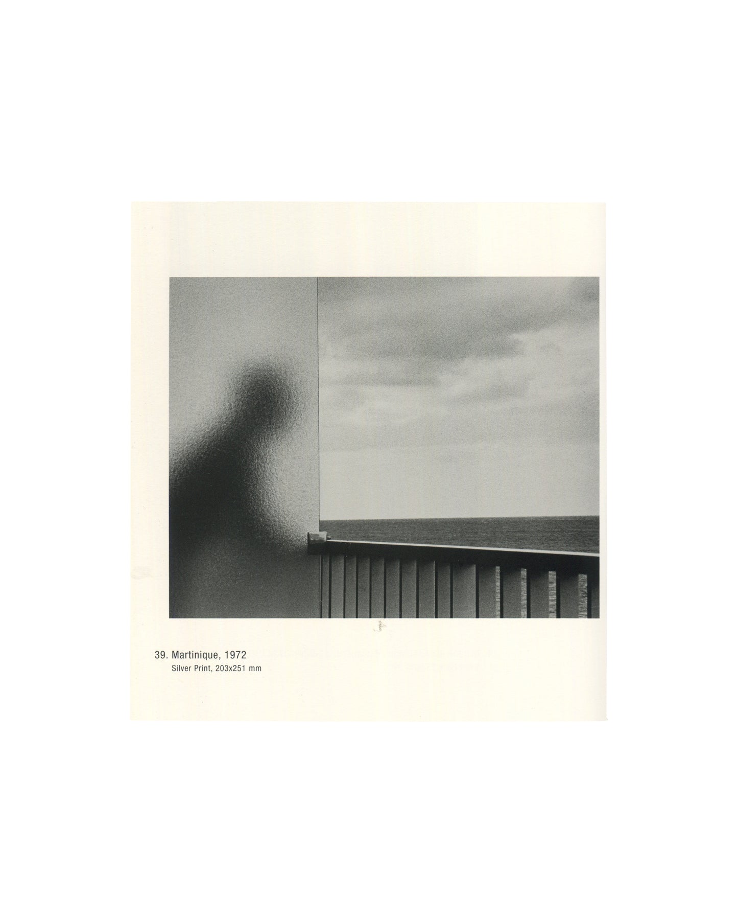Photograph titled Martinique (1972), showing a shadowy human silhouette behind textured glass overlooking the sea.