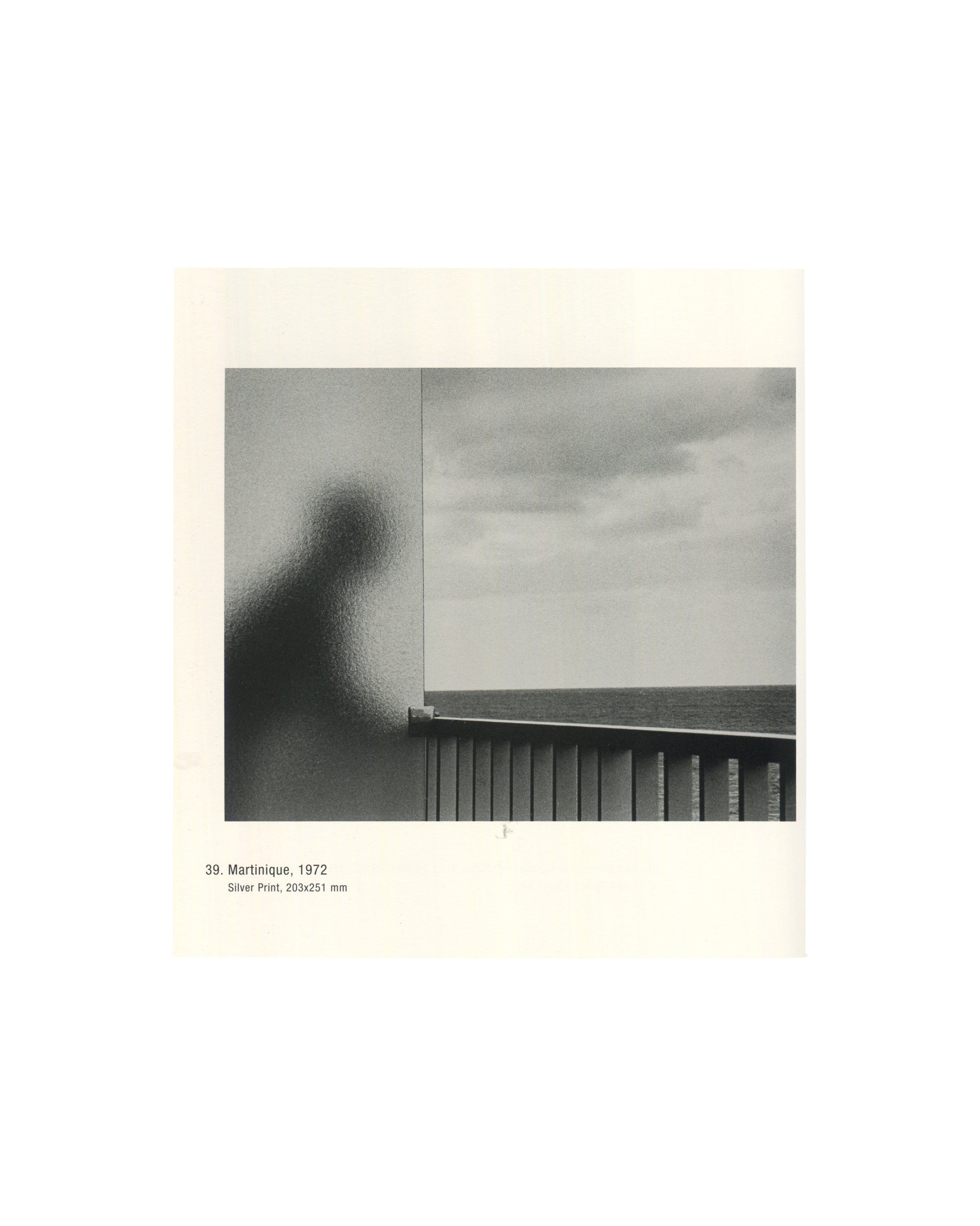 Photograph titled Martinique (1972), showing a shadowy human silhouette behind textured glass overlooking the sea.