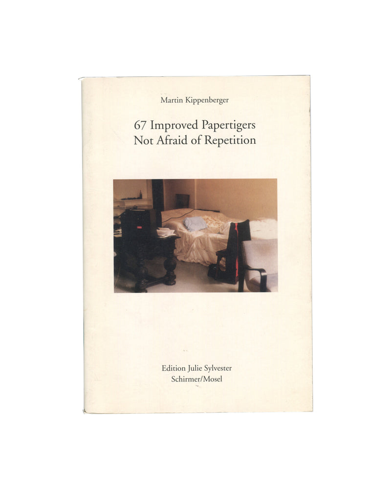 Original 2012 Martin Kippenberger 67 Improved Papertigers Not Afraid of Repetition, Edition Julie Sylvester / Schirmer/Mosel. Front cover showing a colour photograph of a dishevelled hotel room interior: an unmade bed with a gold bedspread, a black office chair, and a portable television on a stand. Title in small serif type upper centre: 'Martin Kippenberger / 67 Improved Papertigers / Not Afraid of Repetition'. Publisher imprint 'Edition Julie Sylvester / Schirmer/Mosel' lower centre. Cream wrappers.