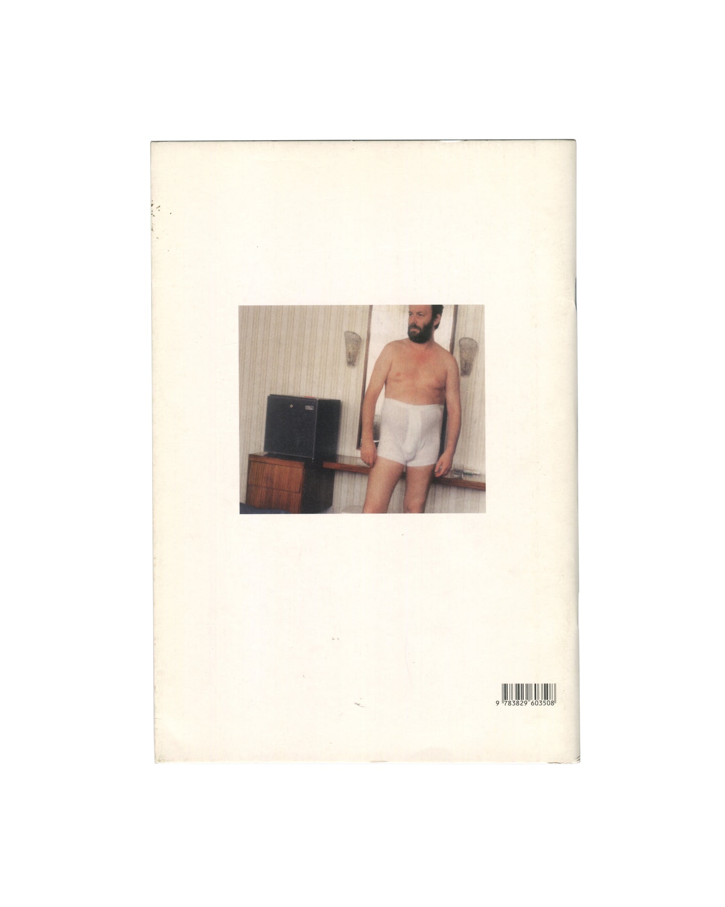 Reverse of 2012 Martin Kippenberger 67 Improved Papertigers Not Afraid of Repetition, Schirmer/Mosel. Back cover showing a colour snapshot photograph of a bearded man in white underwear standing in a hotel room, looking down, with a television and wood-panelled wall behind him. ISBN barcode 9783829603508 lower right. Cream wrappers with handling wear.