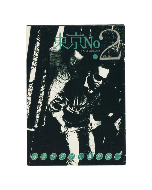 `Keizō Kitajima — 東京 No. 2 (Tokyo No. 2), Photo Express Tokyo, February 1979. Front cover. High-contrast black and white photograph of two figures in close proximity, faces partially obscured, one in a leather jacket, set against a dark ground with diagonal structural elements. Title in teal kanji and Latin type upper centre: 東京 No 2. Date and price: 1979. FEBRUARY · 200 YEN. Green circular stamps along foot reading: 写 真 特 急 便 〒 北 島 敬 三 (Photo Express Mail, Kitajima Keizō).`