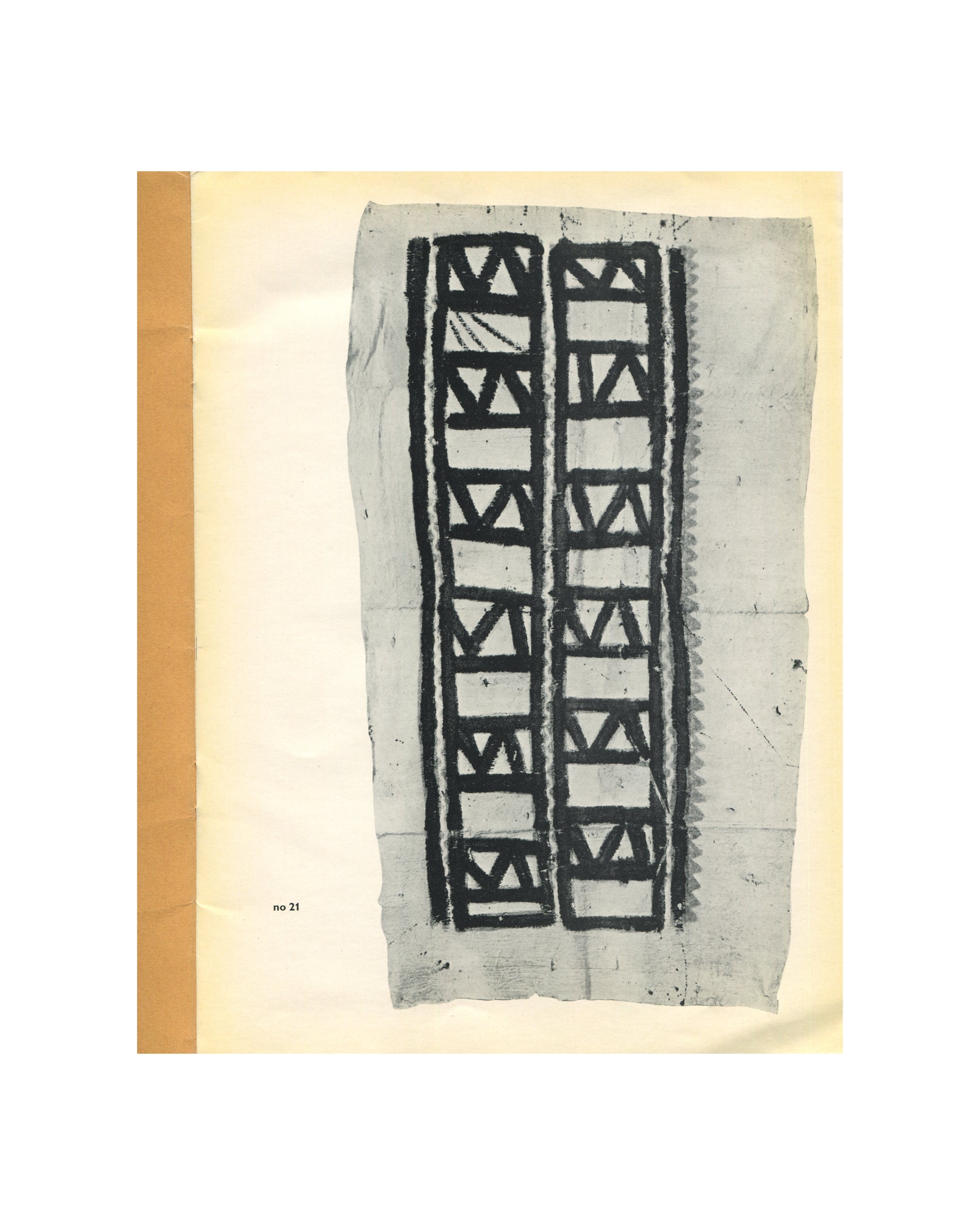 `Kunst uit Nieuw Guinea, 1963 — interior plate. Black and white photograph of catalogue no. 21: a painted bark cloth panel with two vertical columns of bold geometric ornament — repeating rectangular frames enclosing diagonal and triangular forms in dark pigment on pale ground. Cloth shows fold lines and surface wear. New Guinea textile, date unspecified.`