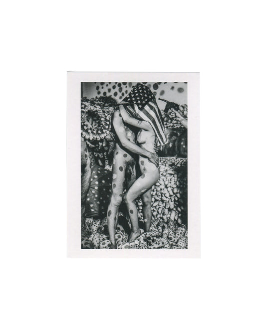 Centre Pompidou postcard reproducing a 1968 black-and-white photograph of two nude performers covered in Yayoi Kusama polka dots embracing beneath an American flag, with a toy gun visible at right and soft-sculpture forms in the background.
