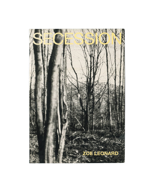 Cover of Zoe Leonard, Secession, Wiener Secession, Vienna, 1997, showing a black-and-white photograph of bare winter trees in a forest with the title SECESSION in large pale yellow sans-serif capitals at upper left and ZOE LEONARD in the same type at lower right.