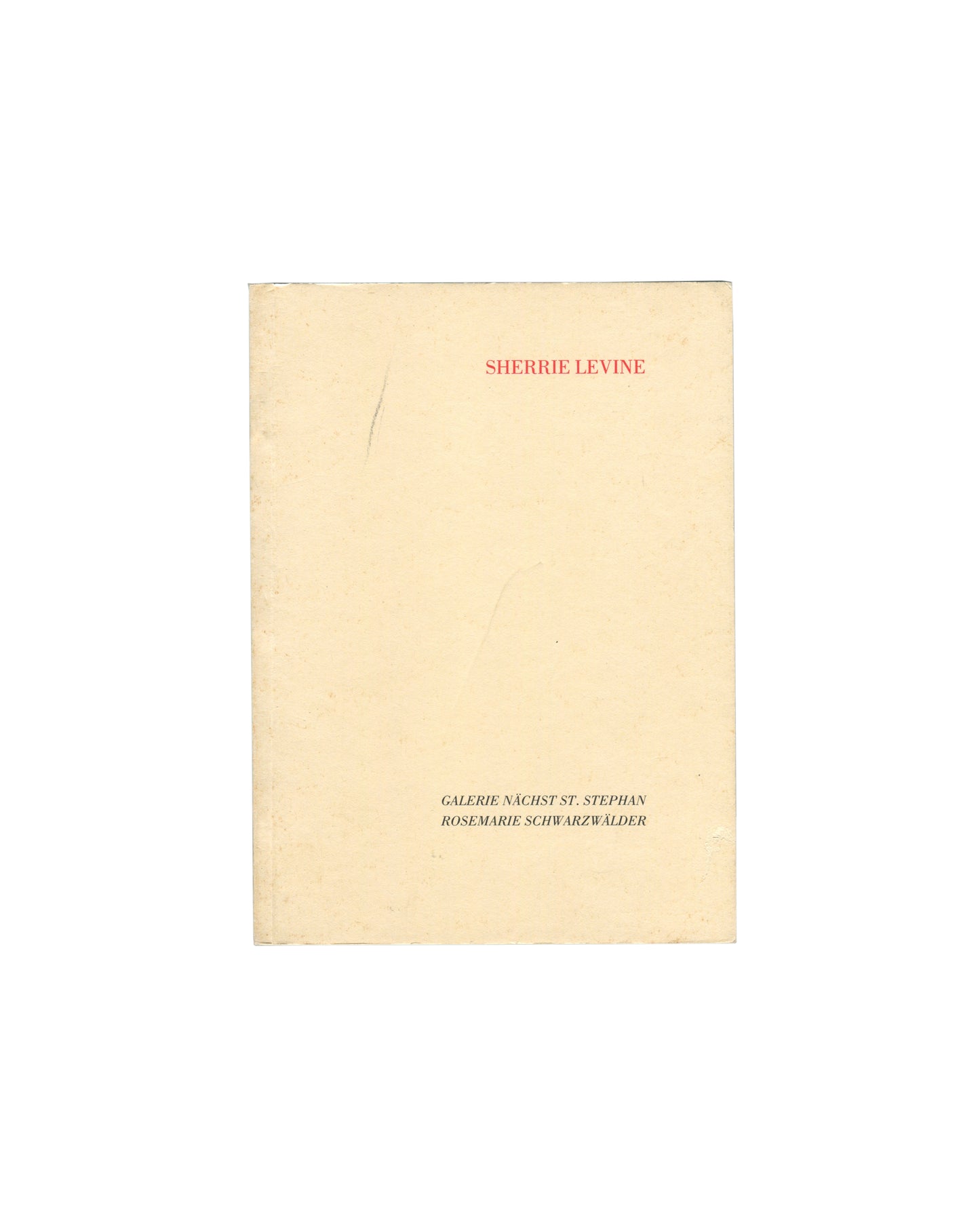 Cover of Sherrie Levine, Galerie nächst St. Stephan Rosemarie Schwarzwälder, Vienna, 1988, showing a plain cream-yellow softcover with SHERRIE LEVINE in small red serif capitals at upper centre and GALERIE NÄCHST ST. STEPHAN / ROSEMARIE SCHWARZWÄLDER in small black serif capitals at lower centre, with a faint vertical pencil mark at left.