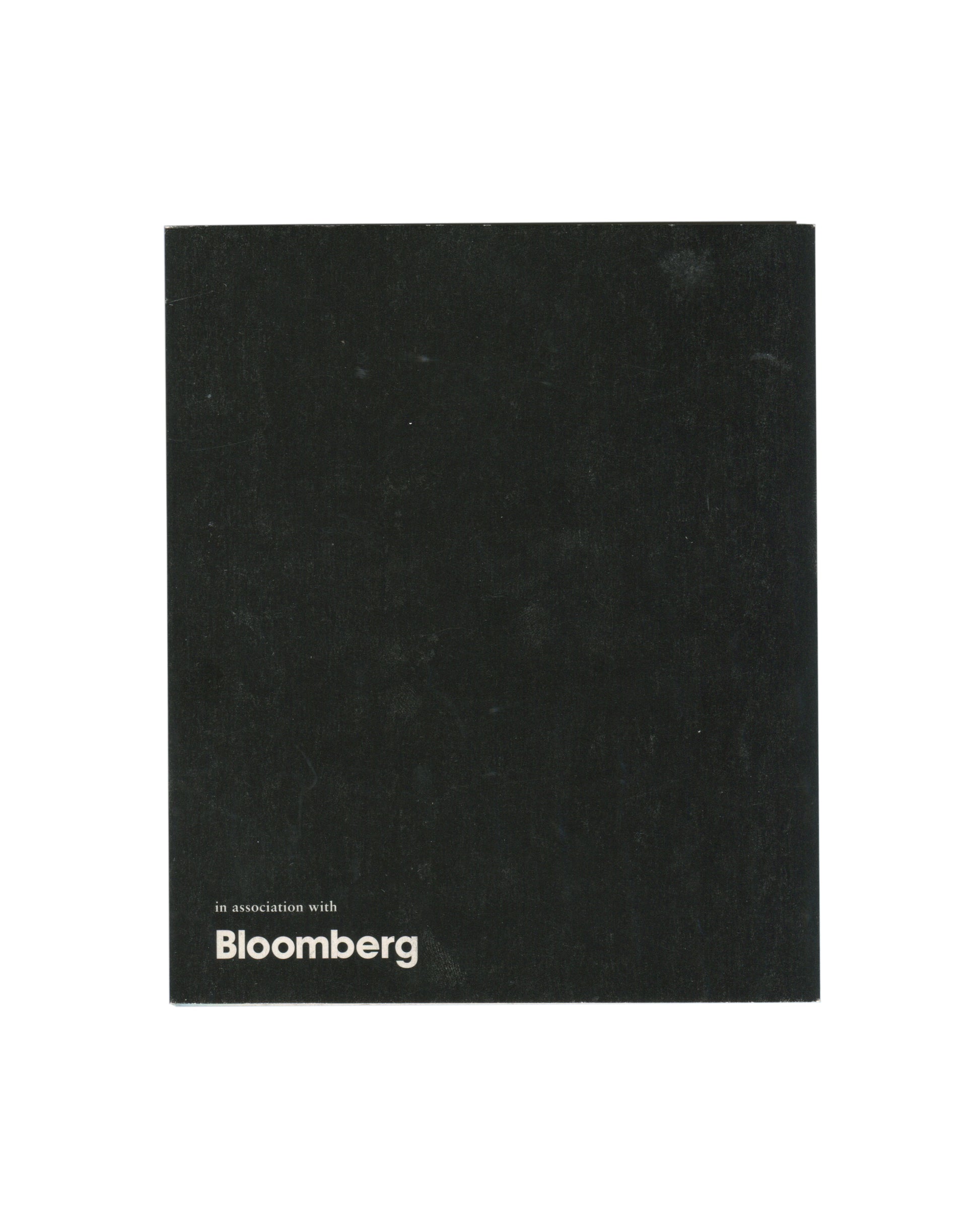 Reverse of 2000 fig-1 exhibition invitation for Patti Smith / Robert Mapplethorpe, Still / Moving, London, plain black card with in association with Bloomberg in small white sans-serif type at lower left.